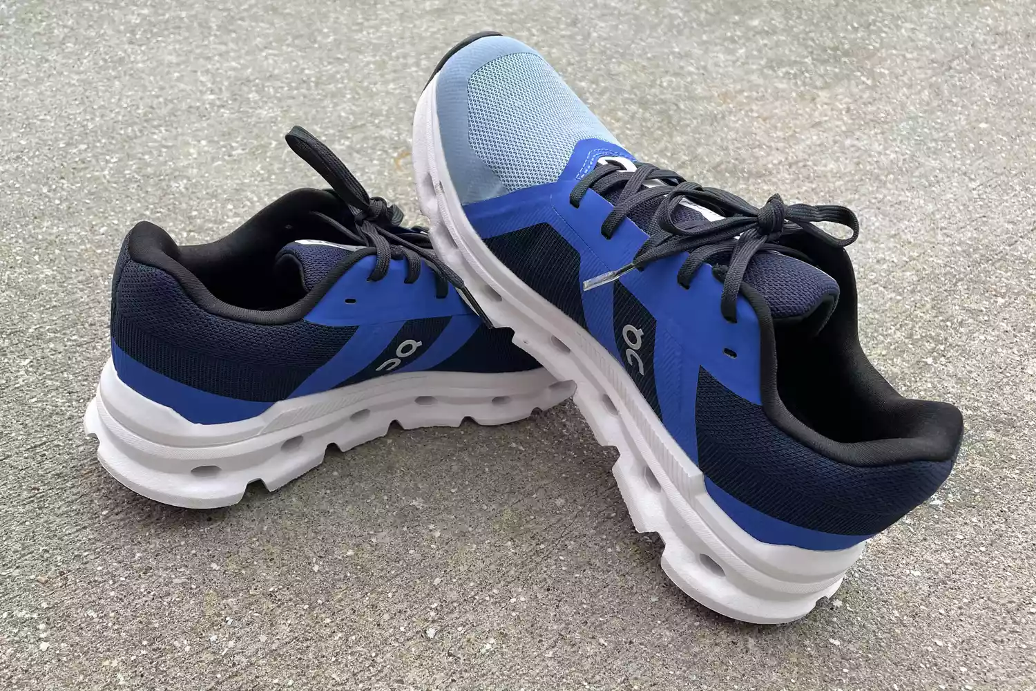 On Women's Cloudrunner shoes sitting on top of each other on concrete 