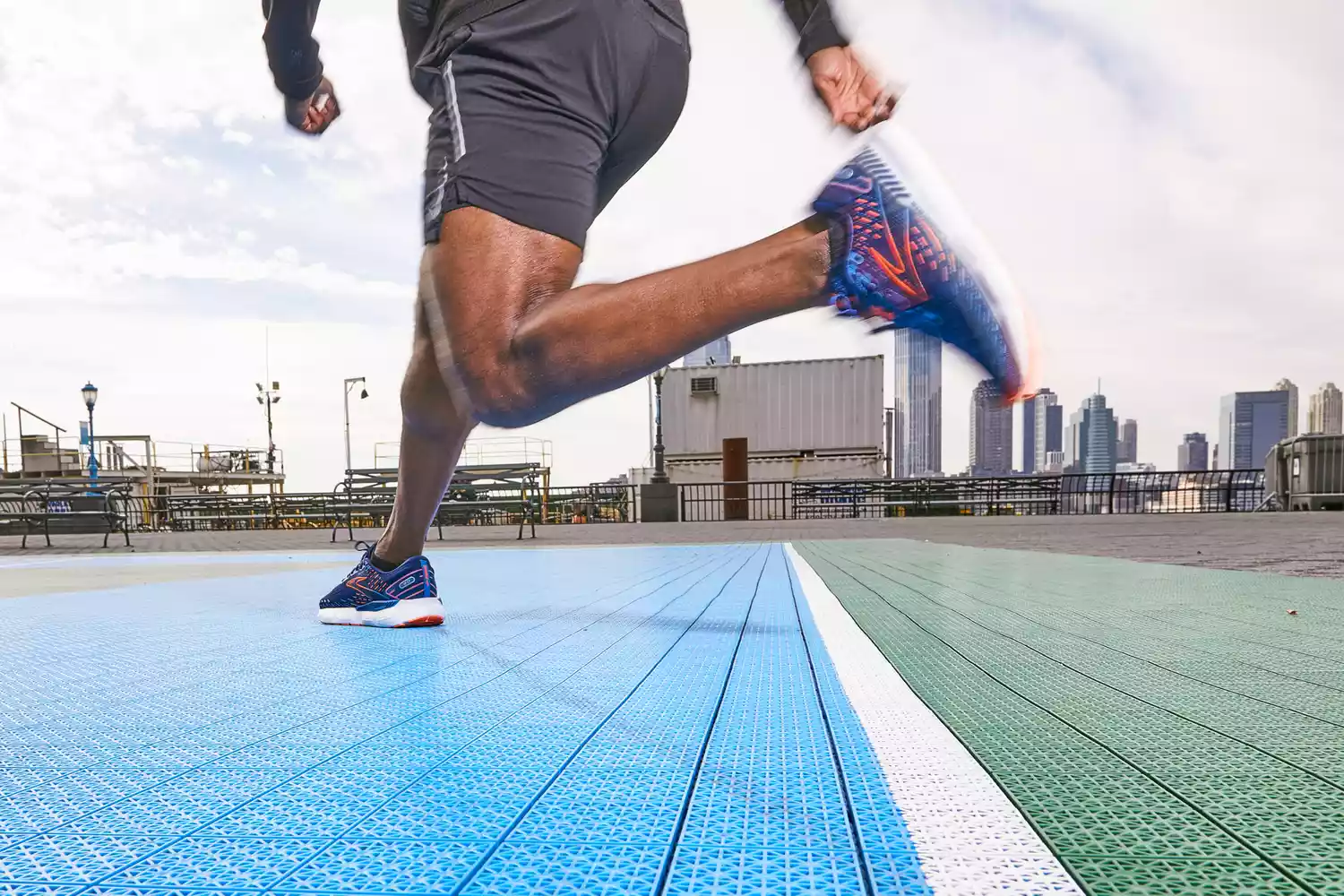 A person running on an outdoor court wearing Brooks Men's Glycerin GTS 20 Running Shoe