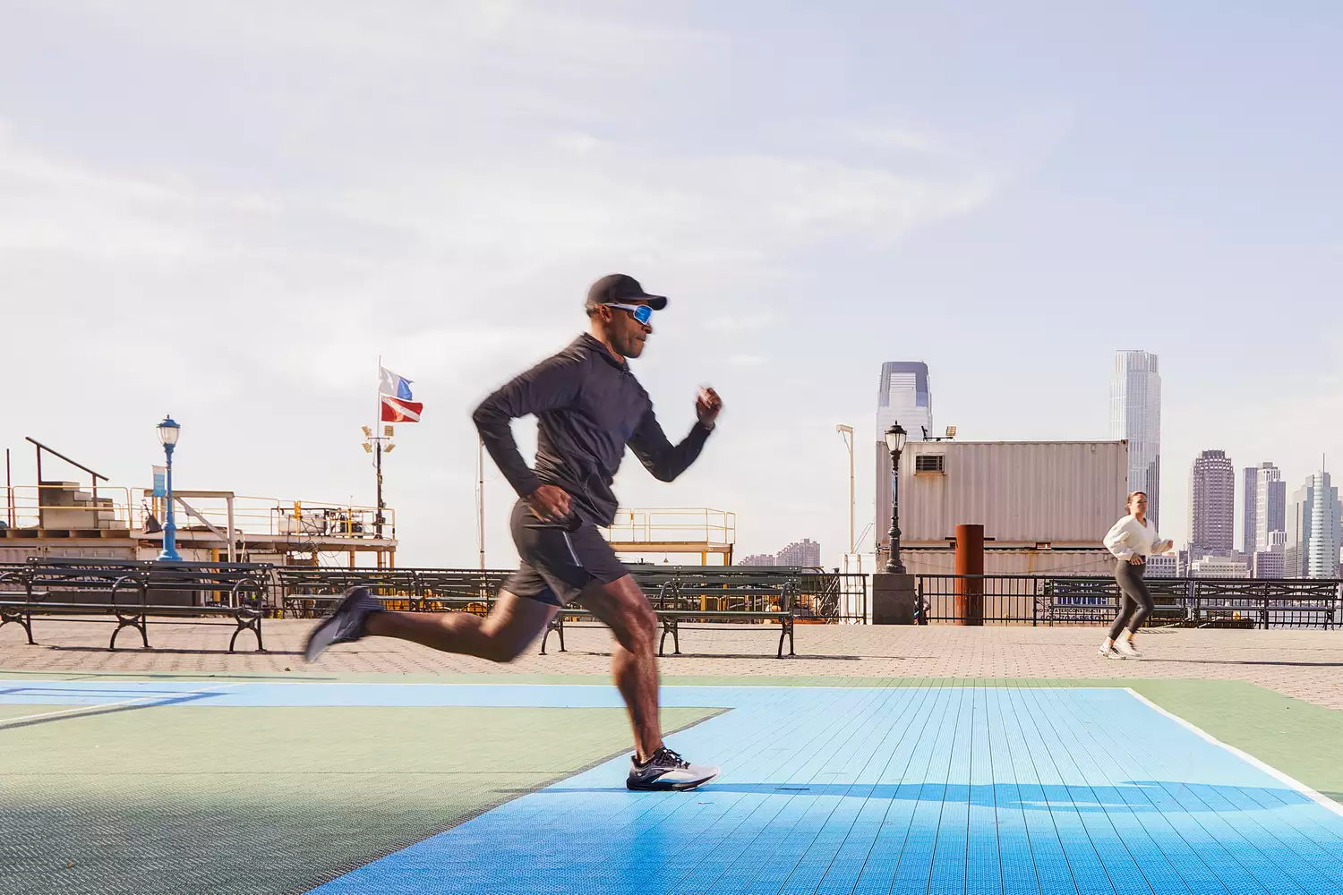 A person running on an outdoor court wearing the Brooks Launch 10