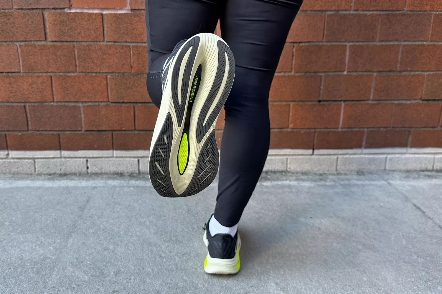 A person shows the bottom of the New Balance Women's FuelCell SuperComp Trainer v2 Running Shoe
