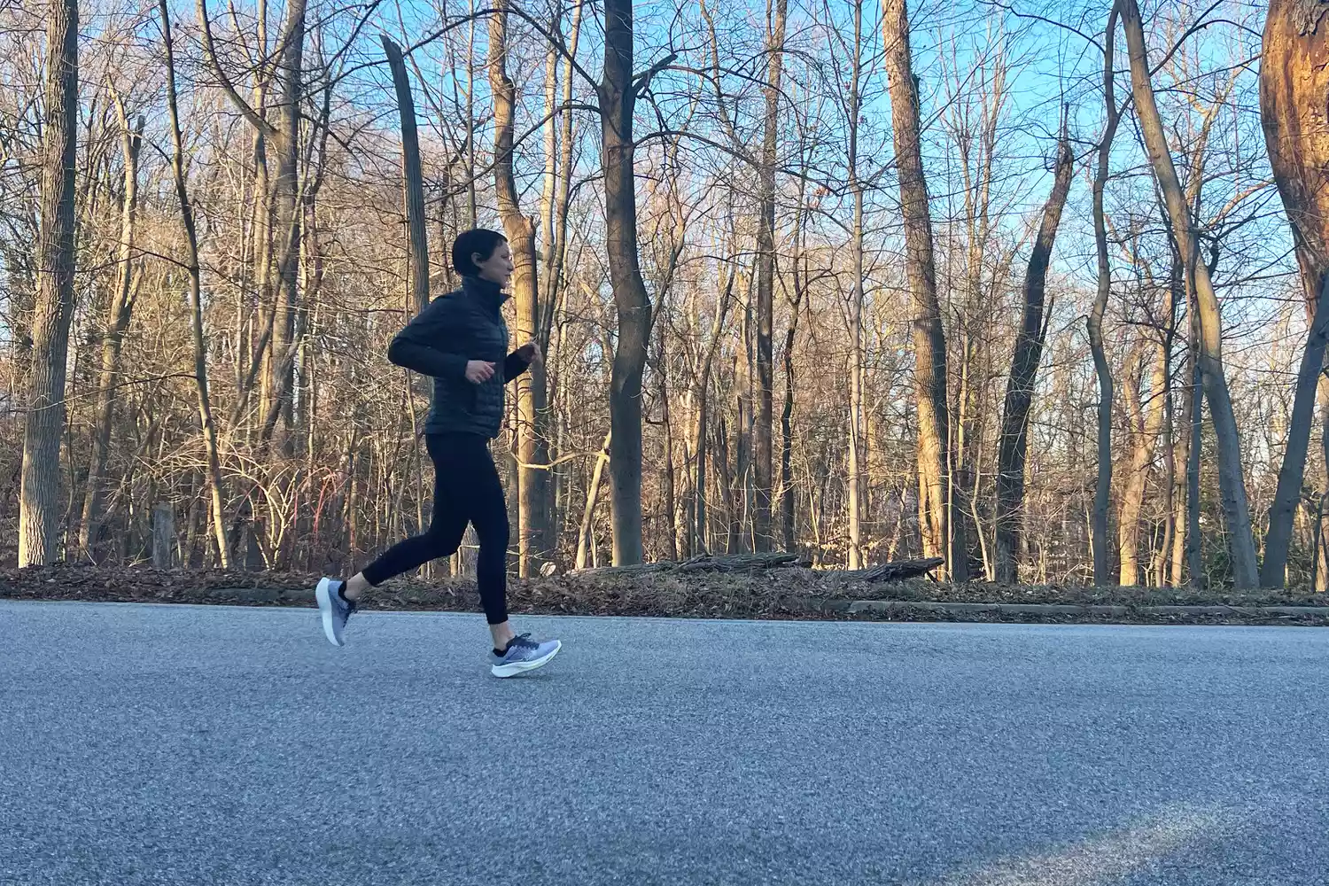 A person runs outside on asphalt while wearing the Saucony Women's Ride 17 Running Shoes
