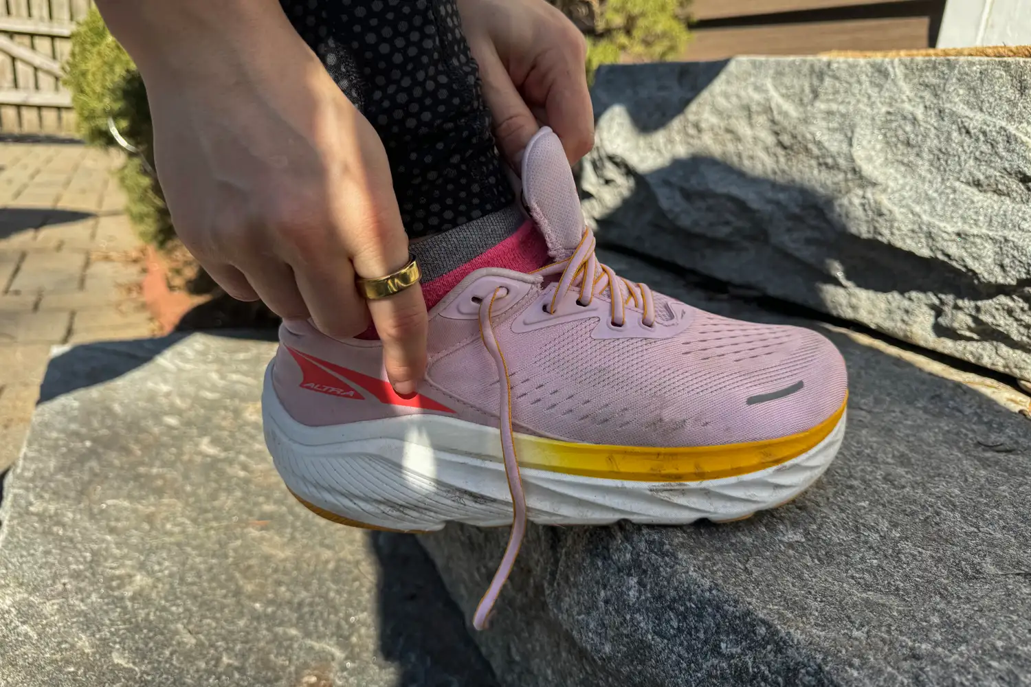 A person puts on the Altra Women's Via Olympus 2 Running Shoe