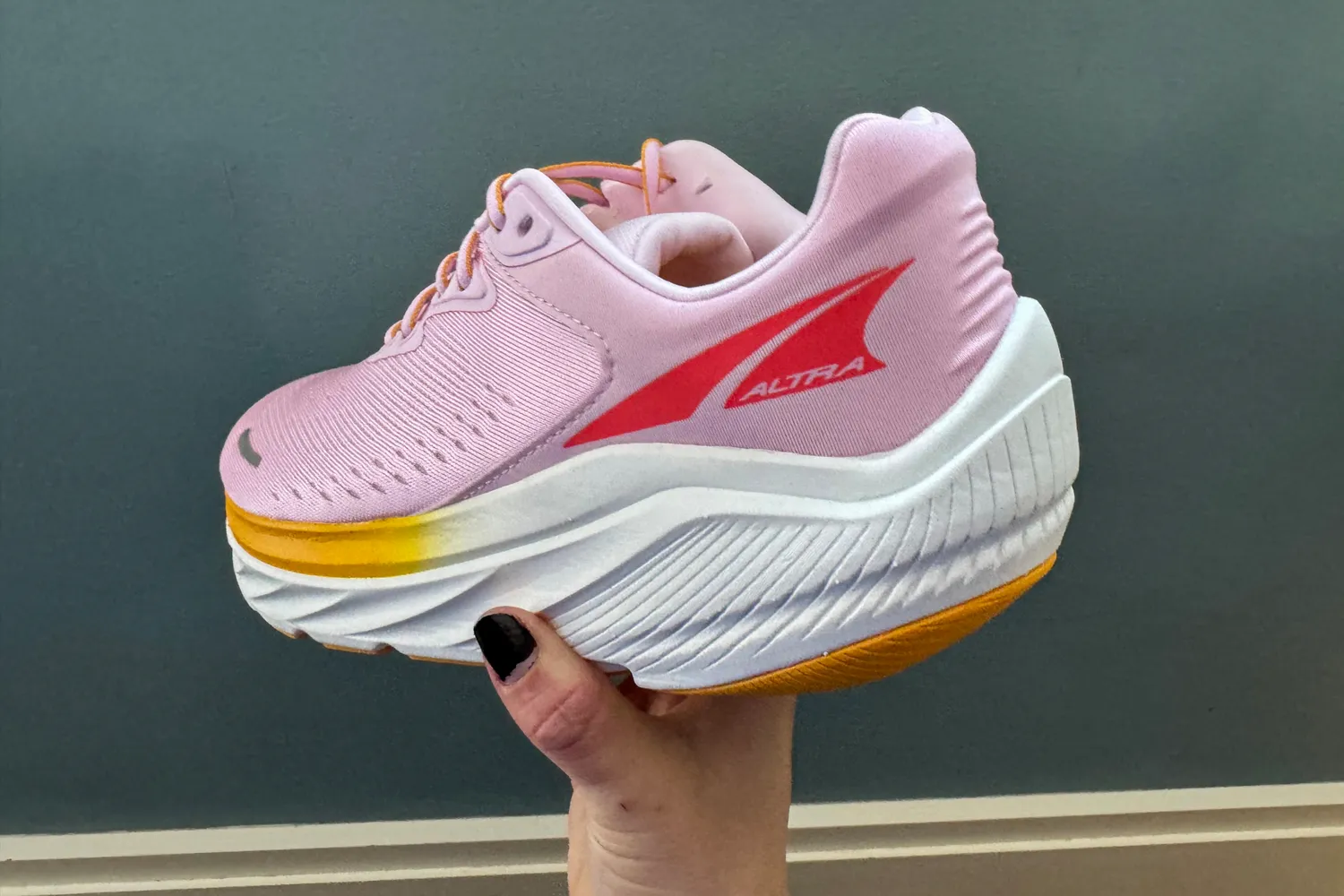 A person holds up the Altra Women's Via Olympus 2 Running Shoe showing the back and side
