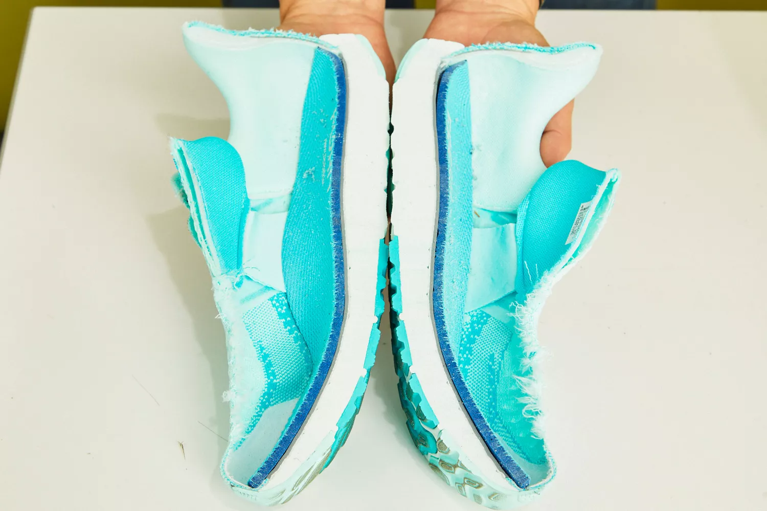 A person holding two cut halves of the New Balance Women's Fresh Foam X 1080 v13