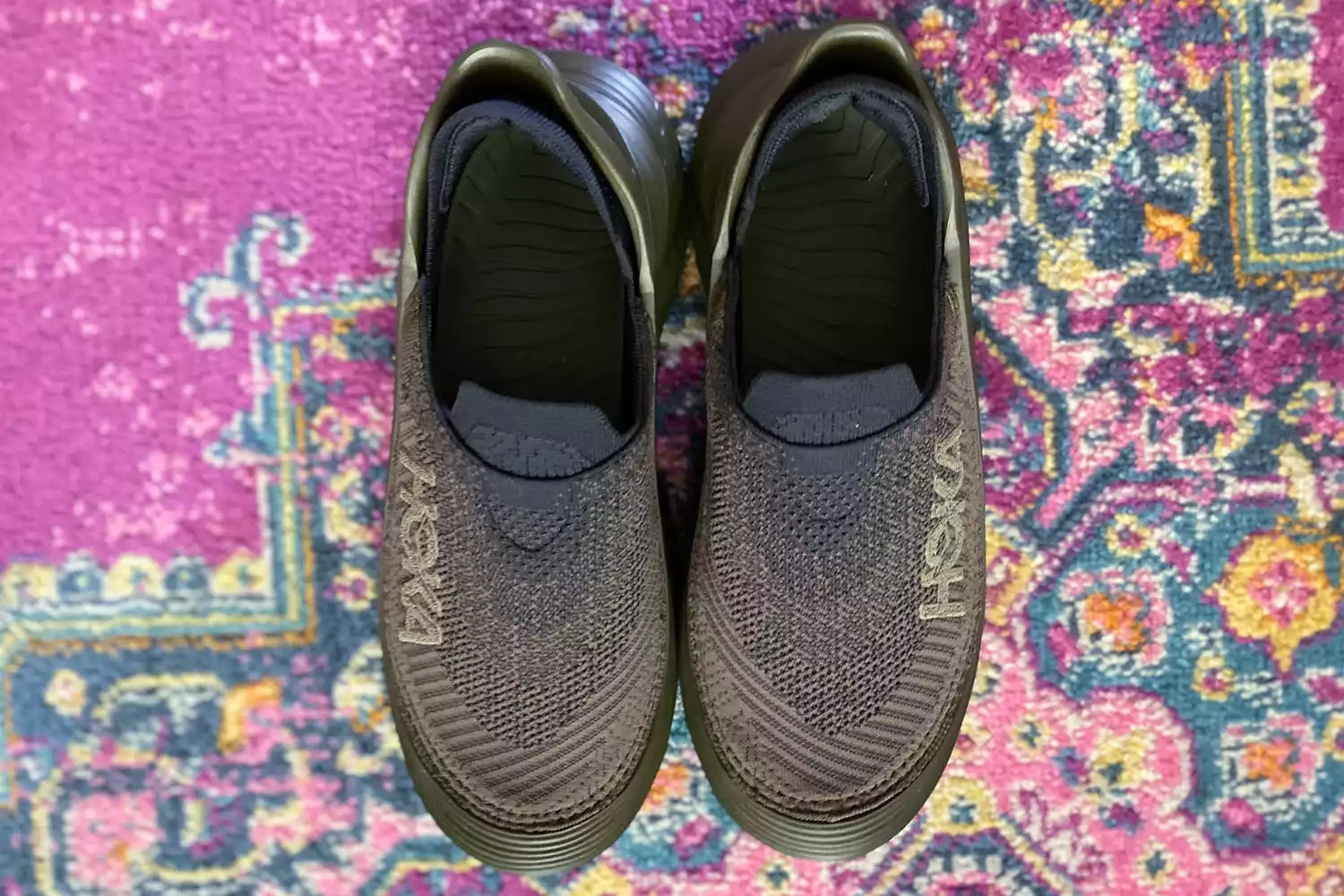 Hoka Restore TC Recovery Shoes on a rug