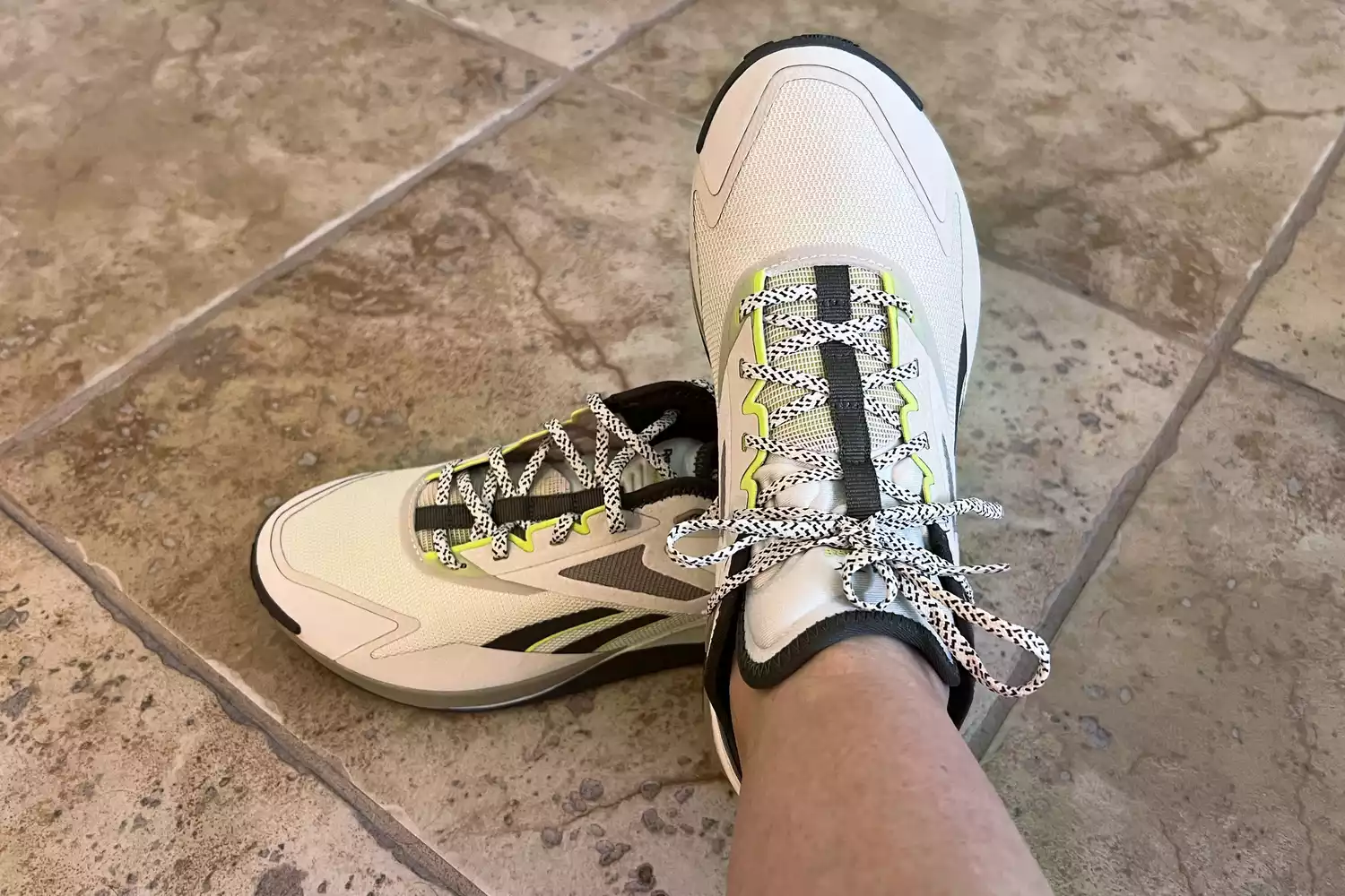 A person wearing a Reebok Nano X3 Adventure Training Shoe on a tile floor