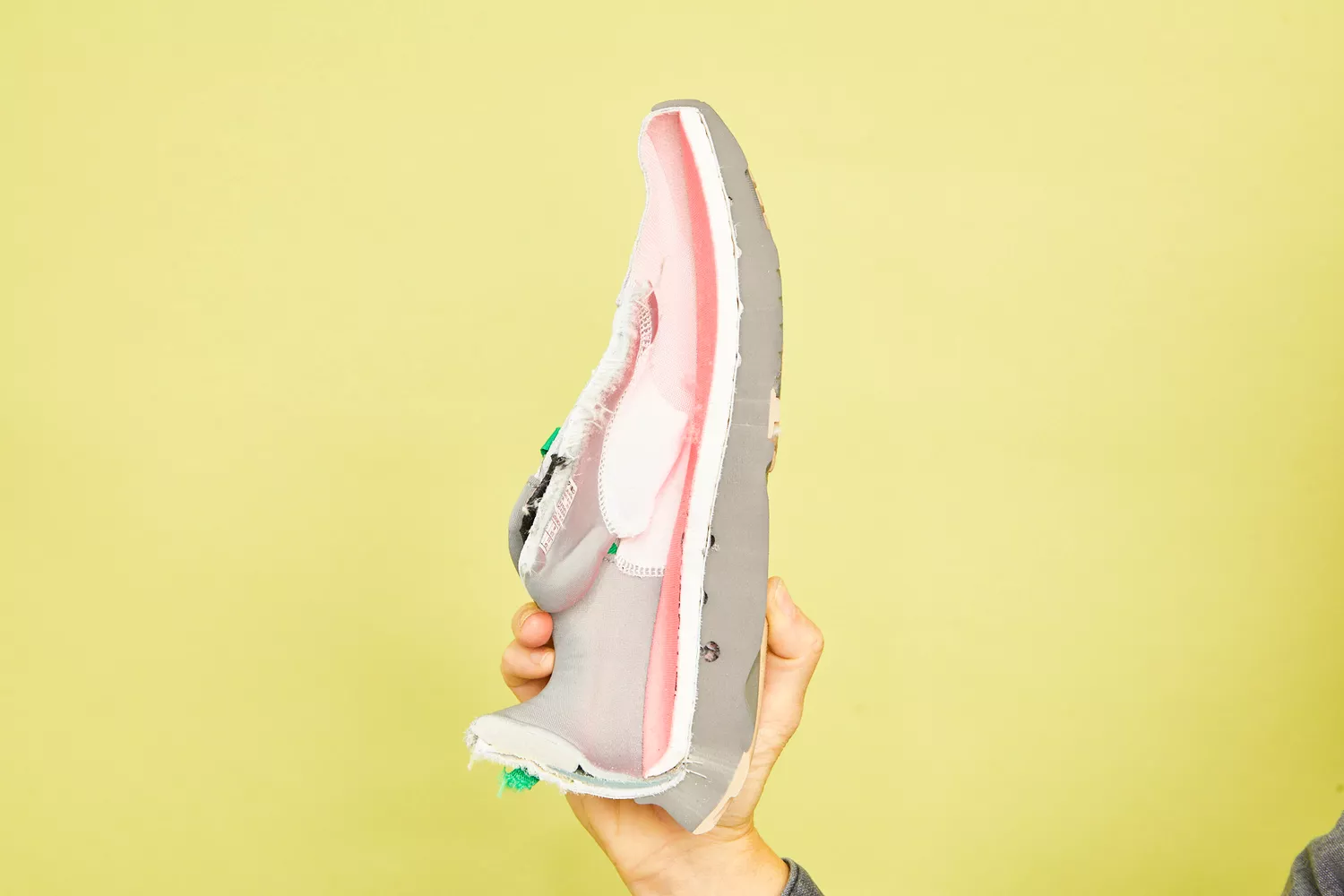 A hand holding the Saucony Women's Guide 16 Sneaker cut in half