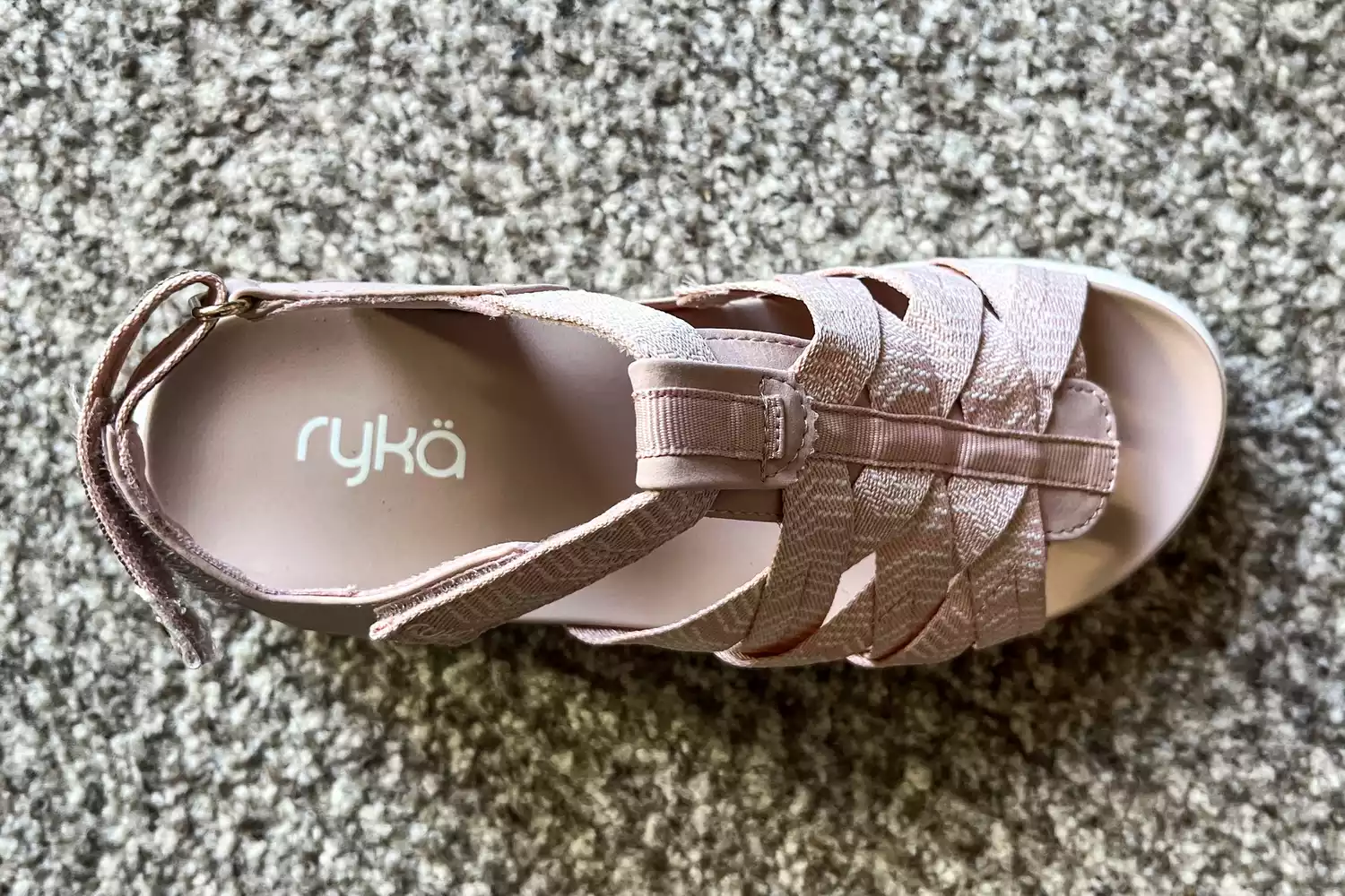 An overhead view of a Rykä Blissful Strappy Sandal on a carpet