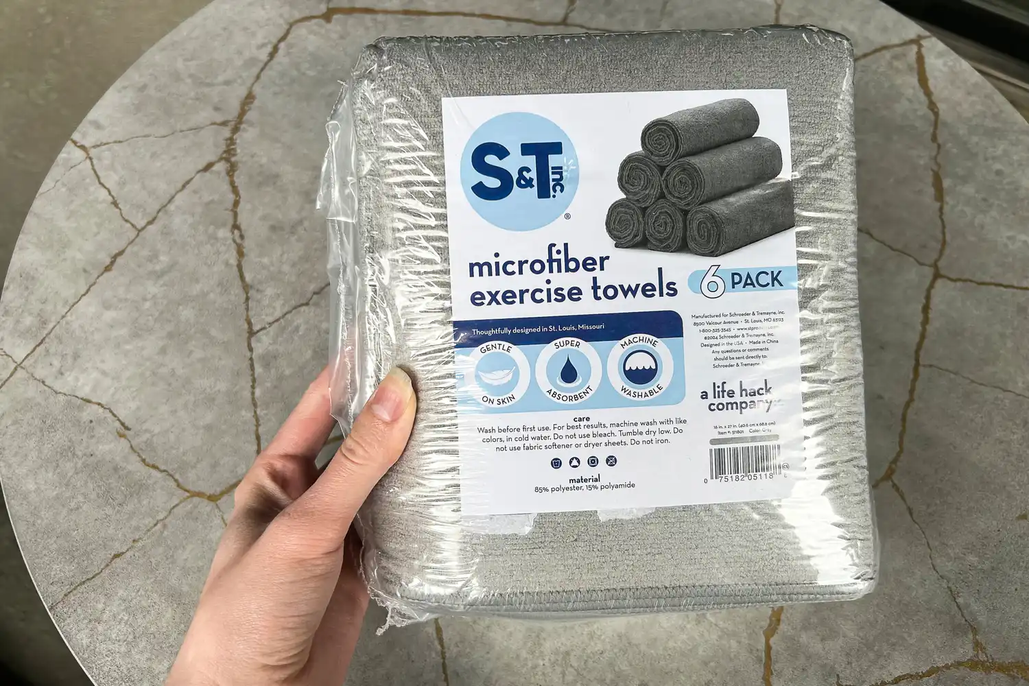 The S&T INC. Microfiber Sweat Gym Towel folded in plastic packaging