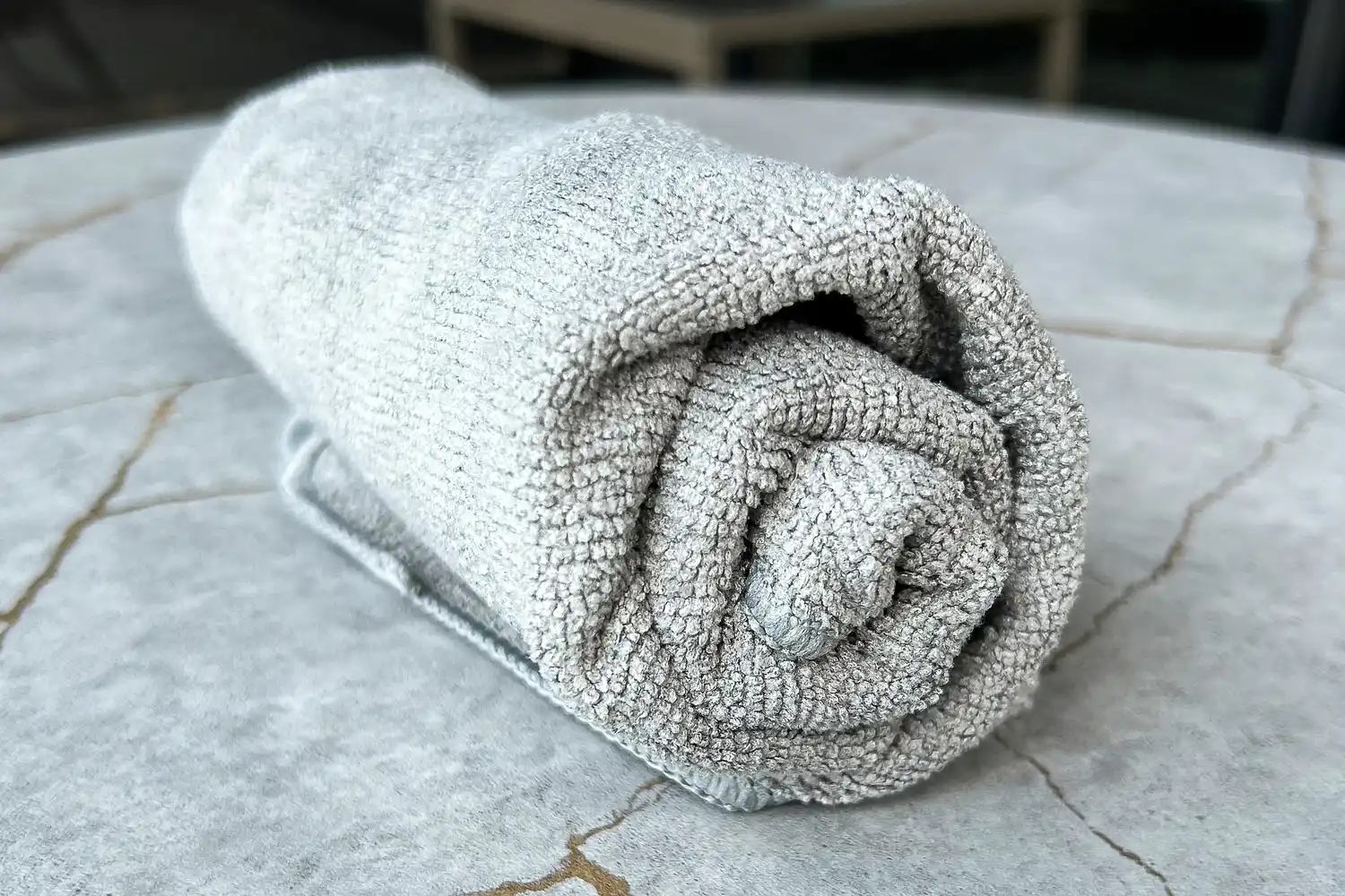 The S&T INC. Microfiber Sweat Gym Towel rolled up on a table