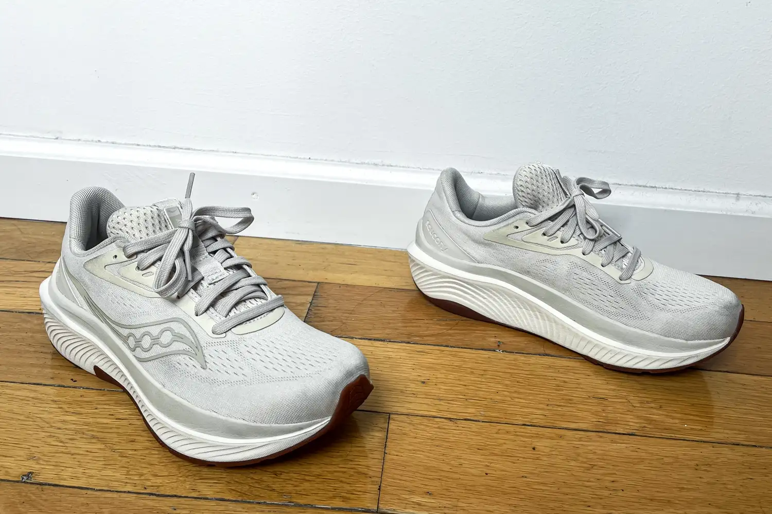 A pair of Saucony Women's Echelon 10 Running Shoes on a wooden floor