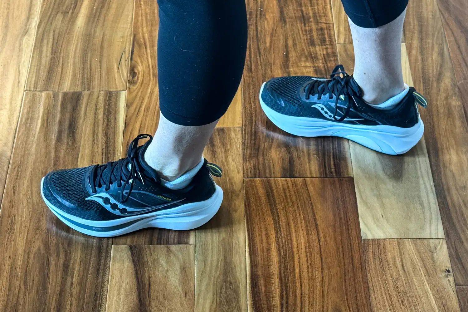 A side view of a person walking on a wooden floor