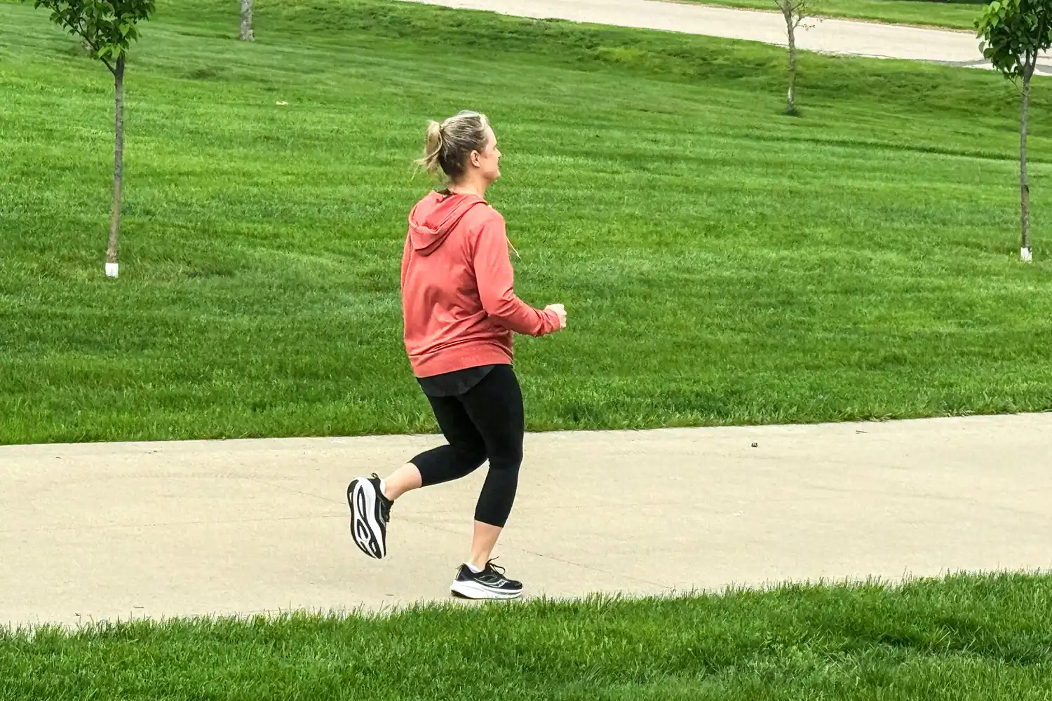 A person runs outside while wearing the Saucony Women's Omni 22 Running Shoes