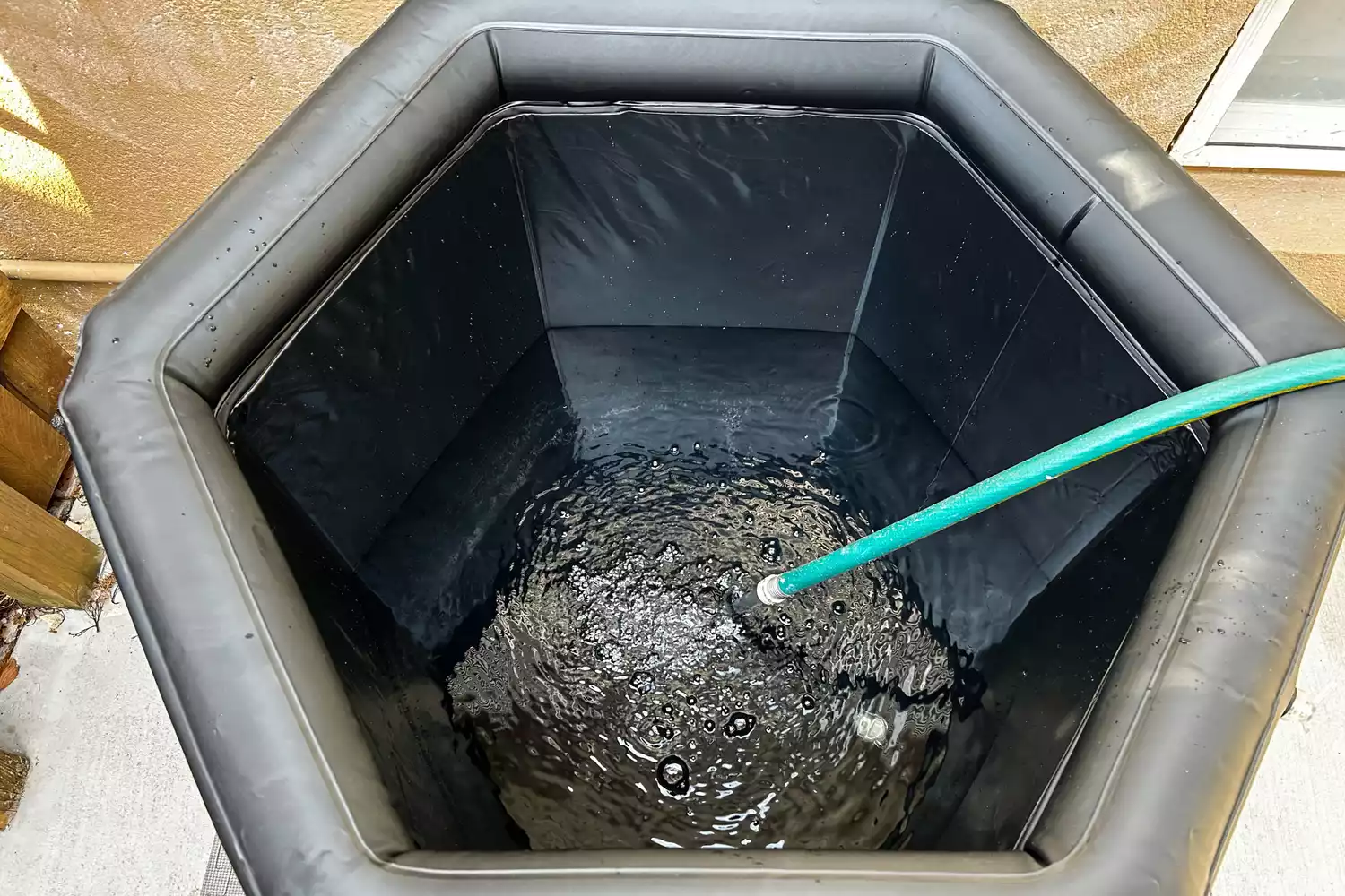 A hose filling the Saunabox PlungeBox Pro with water