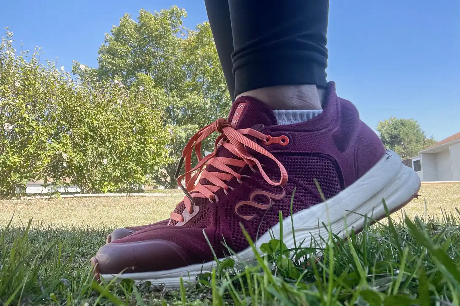 A person wears the Saysh Women's The Felix Runner Performance Running Shoes in grass