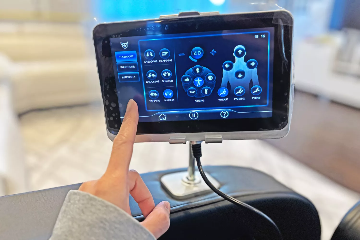 A finger pointing to the display on the SCS Make Life Easy Lifesmart R775W 4D Massage Chair