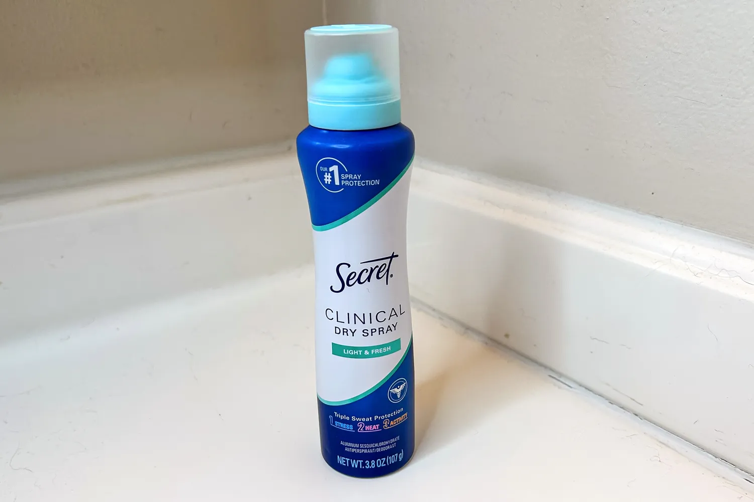 A bottle of Secret Clinical Strength Dry Spray Antiperspirant Deodorant on a countertop