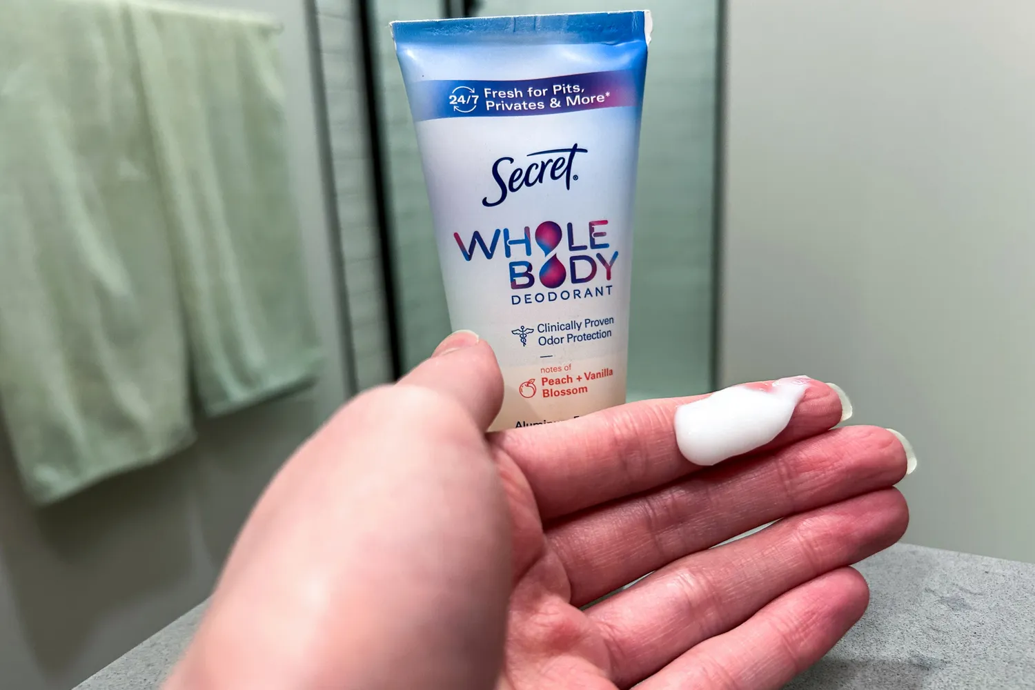 Secret Aluminum-Free Whole Body Deodorant Cream on a person's finger