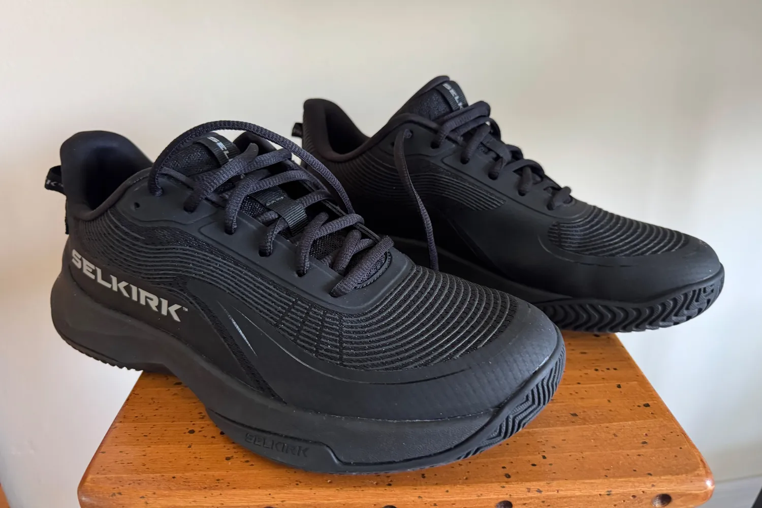 A pair of Selkirk Women's CourtStrike Pro Pickleball Shoes on a small wooden table
