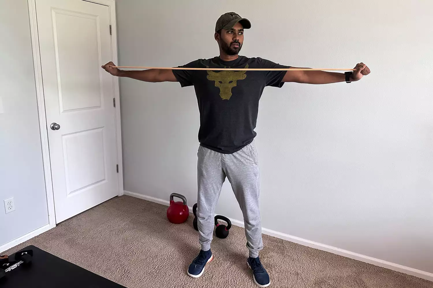 A person stretching a yellow Serious Steel 41 Heavy Duty Resistance Band in front of their chest