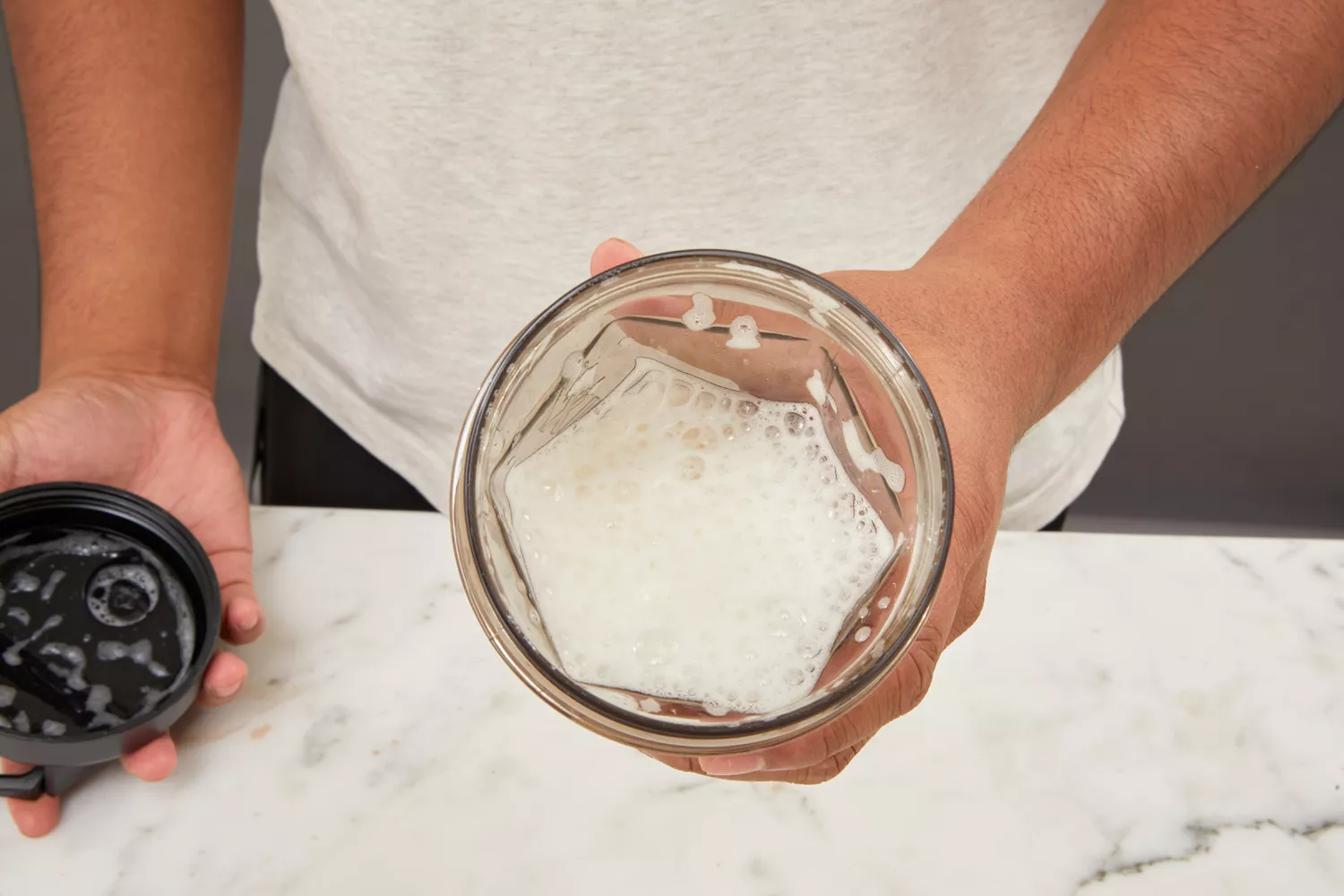 Closeup of a person holding Helimix Vortex Blender Shaker Bottle with drink