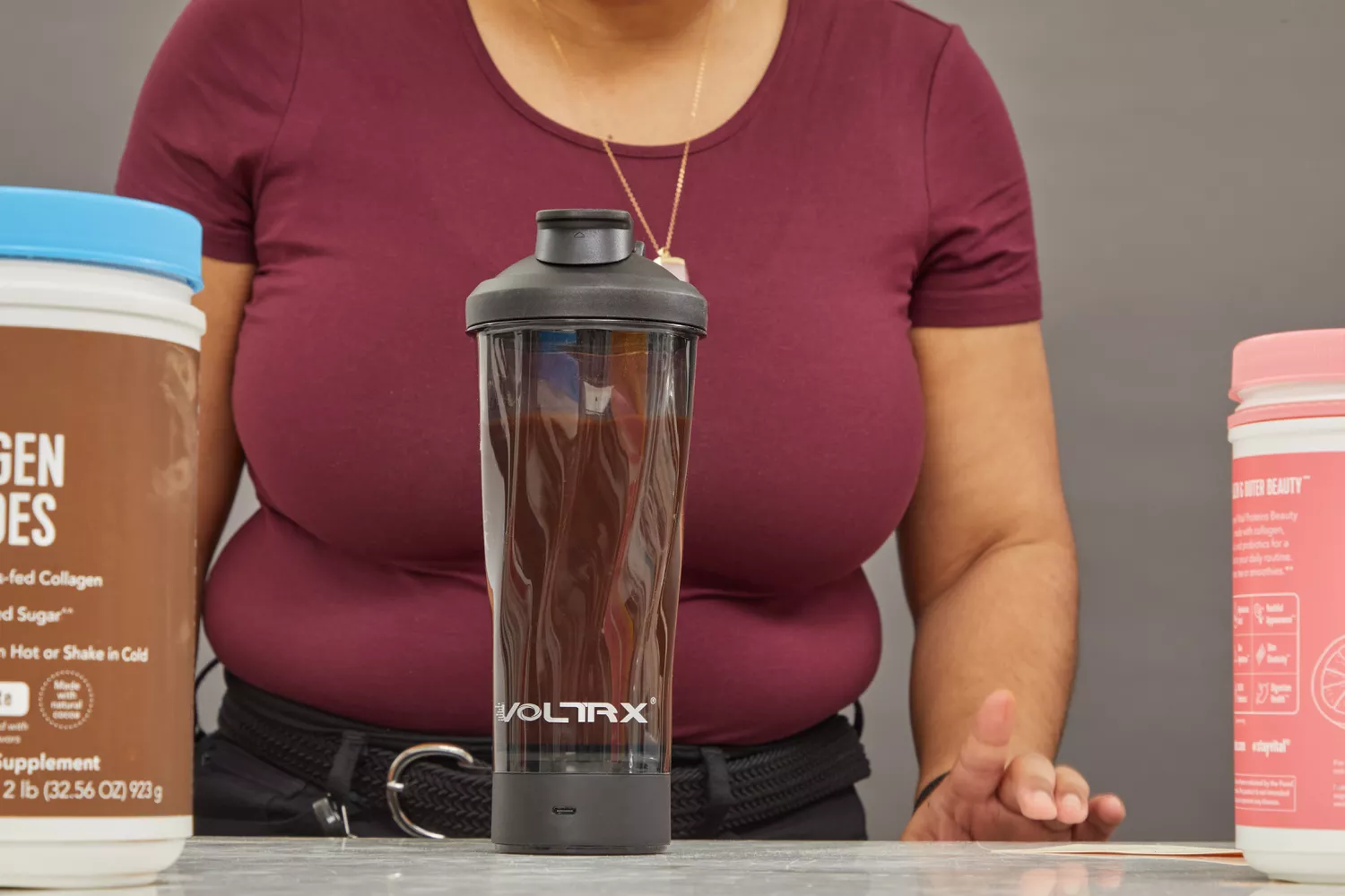Person standing in front of VOLTRX Premium Electric Protein Shaker Bottle