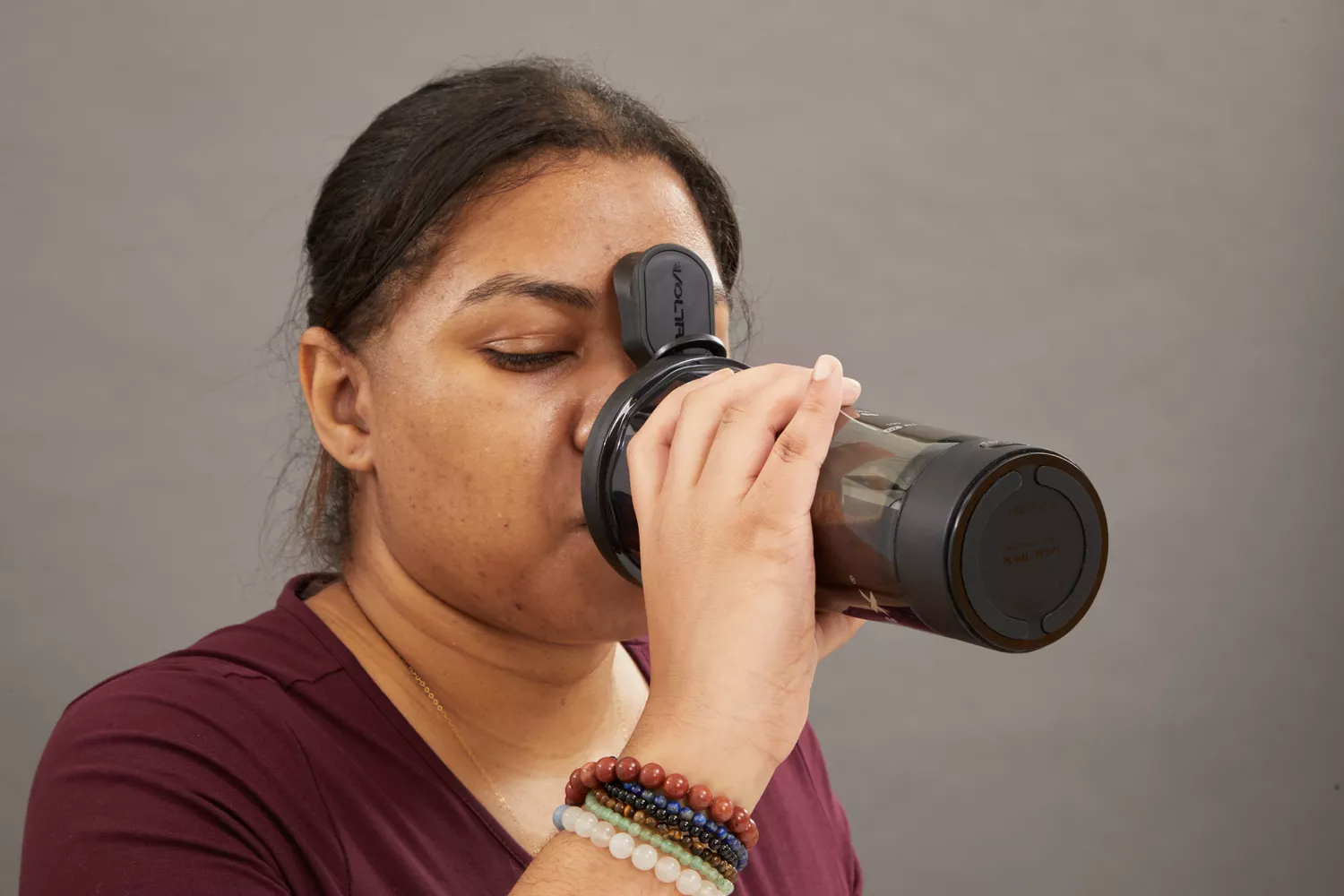Person drinking from VOLTRX Premium Electric Protein Shaker Bottle