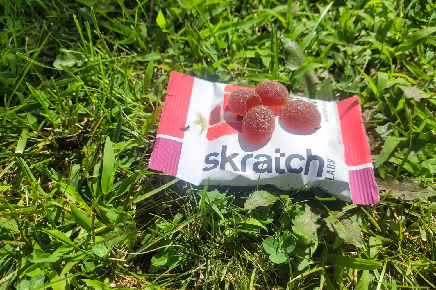 Four Skratch Labs Sport Energy Chews on top of a packet in grass