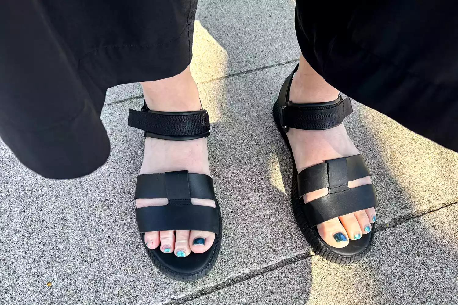 An overhead view of the Sorel ONA AVE Women's Ankle Strap Flat Sandal worn on stones 