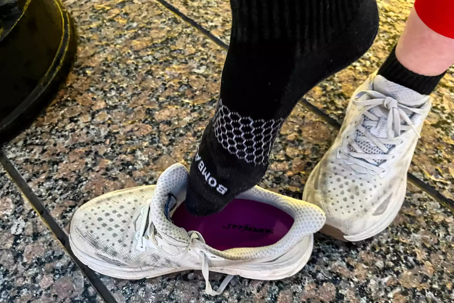 A person puts on sneakers with Superfeet All-Purpose Women's High Impact Support Insoles in them