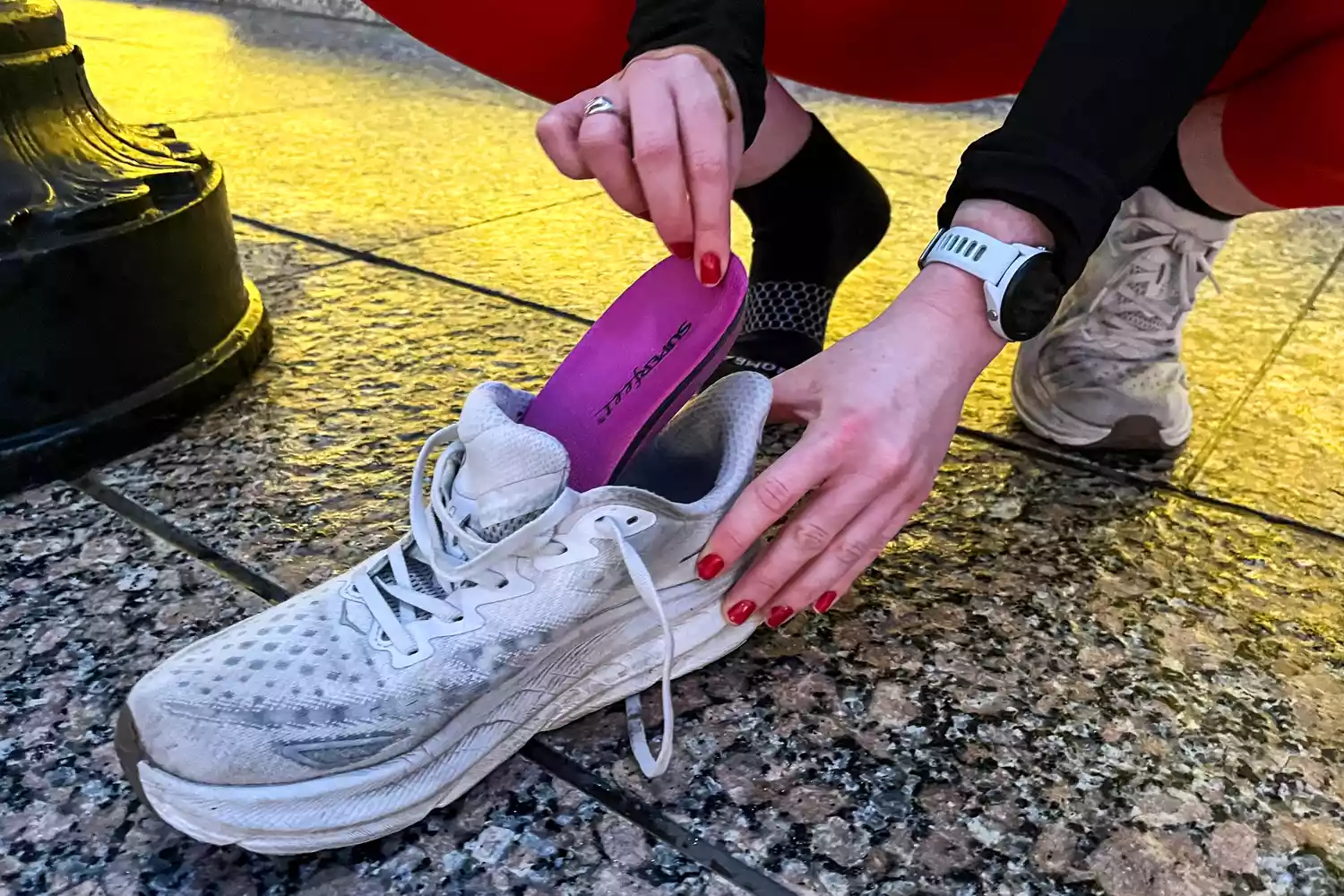 A person places the Superfeet All-Purpose Women's High Impact Support Insole into a sneaker