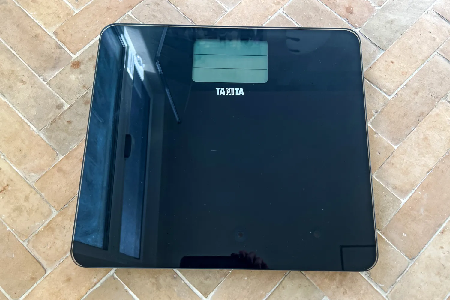 The Tanita HD-384 Digital Bathroom Scale on a brick floor