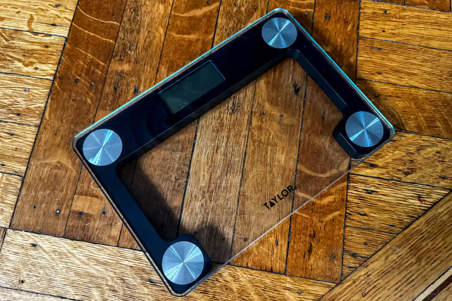 The Taylor Digital Compact Scale with Travel/Storage Tote on a wooden floor