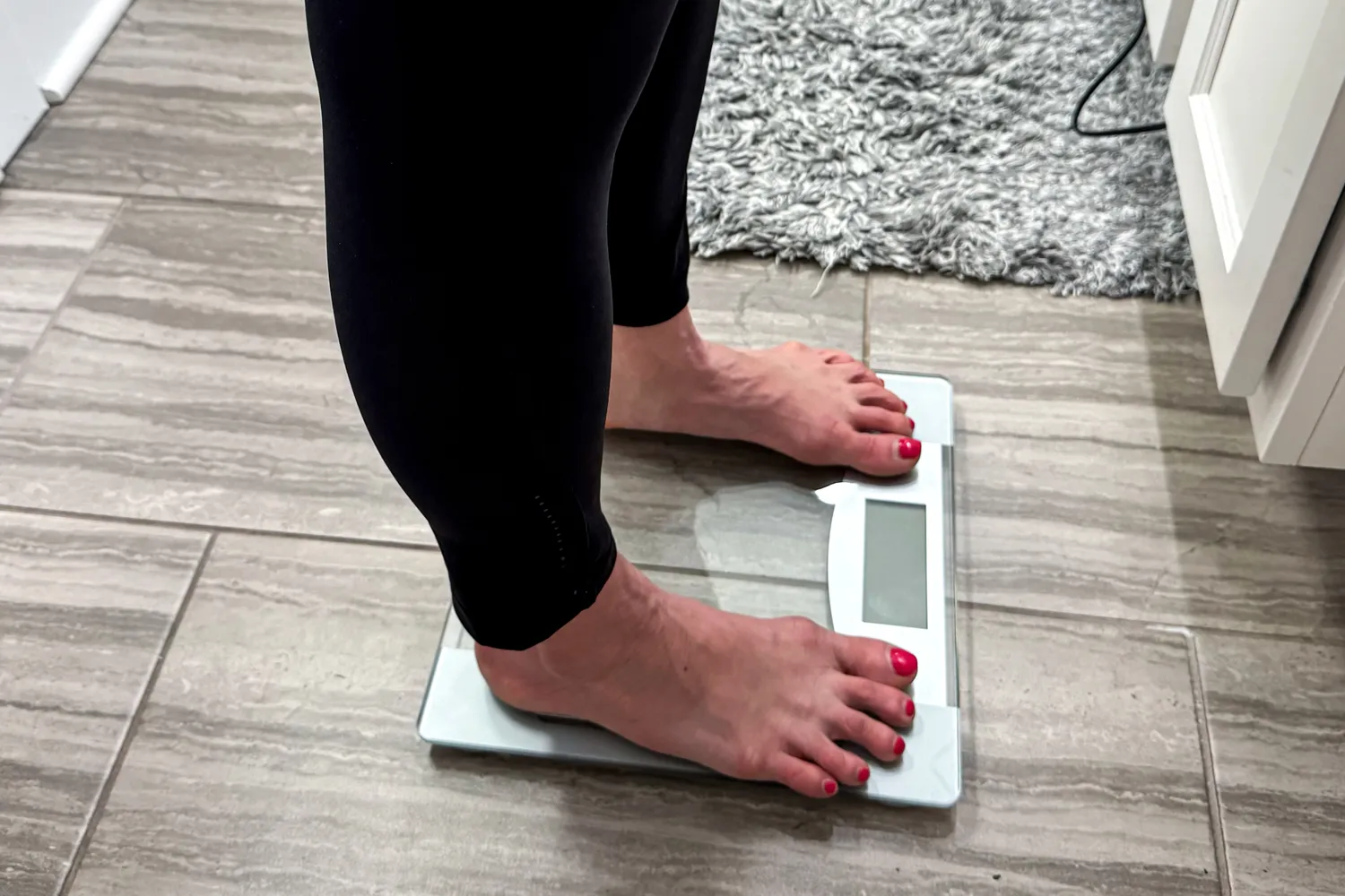 A side view of a person standing on the Taylor Weight Tracking Smart Scale with Bluetooth Sync