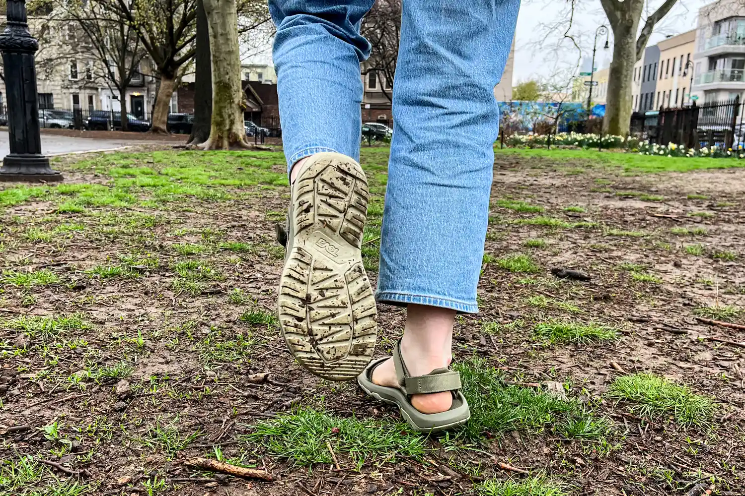 A person showing the bottom of a Teva Women's Hurricane XLT2 sandal worn on dirt