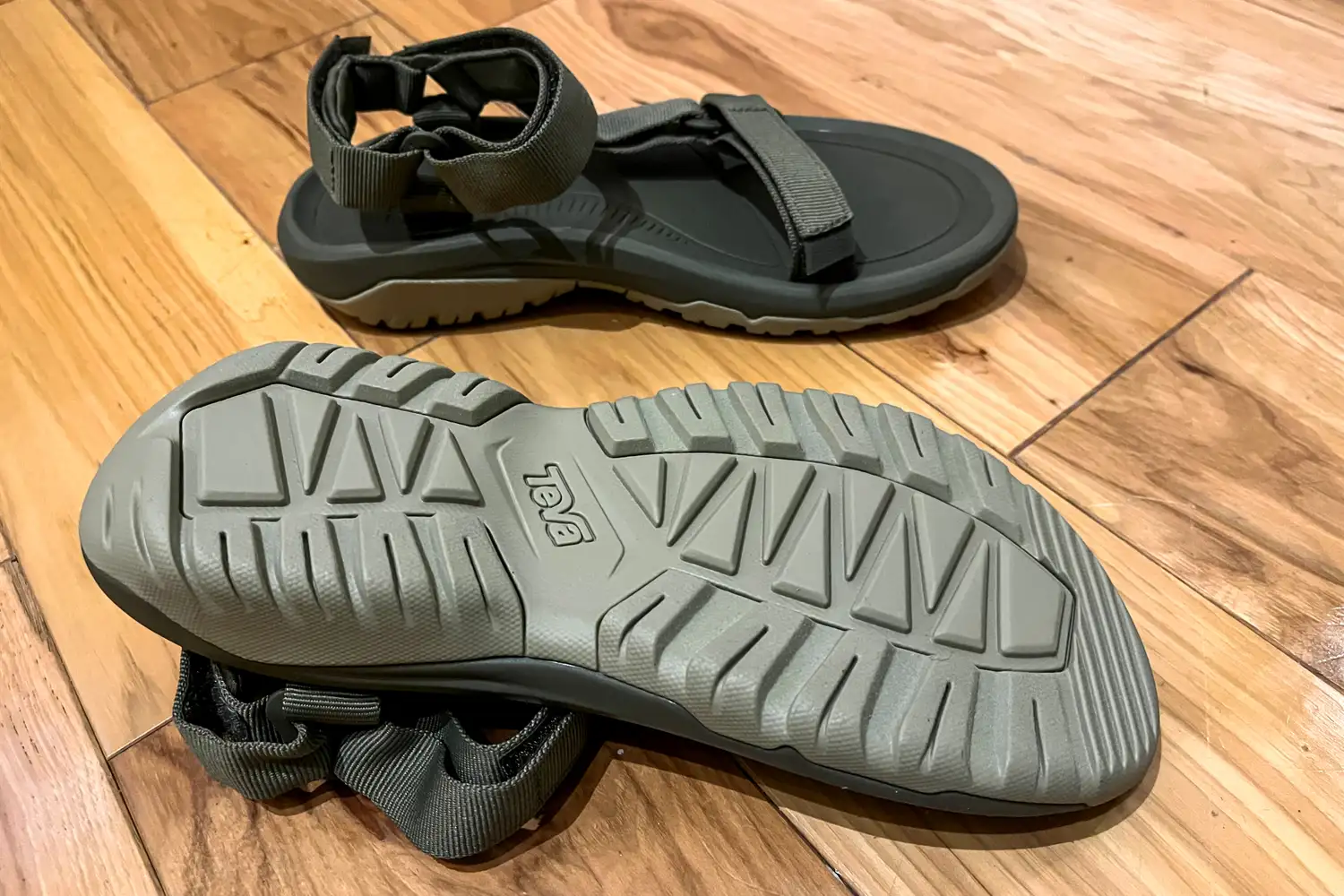 The Teva Women's Hurricane XLT2 sandals posed on wood