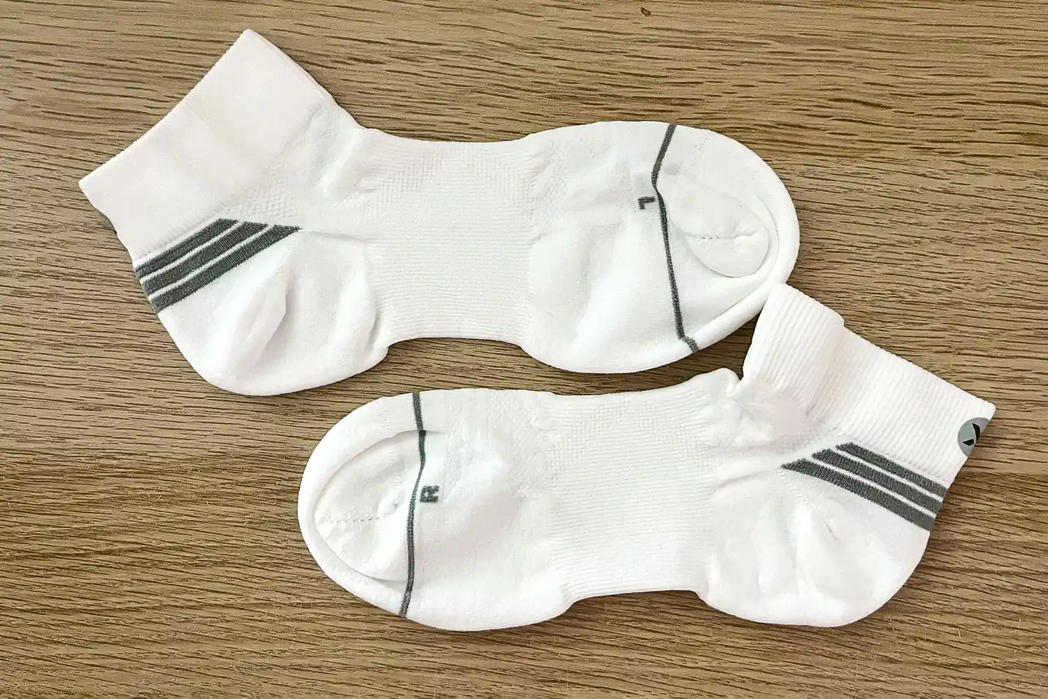 A pair of Thorlo EXRUN003 Experia X SPEED Performance Cushion Ankle Socks on a wooden table