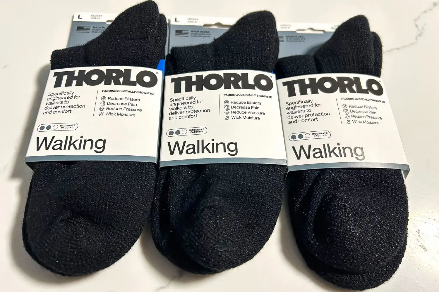 Three pairs of Thorlo WMX Moderate Cushion Ankle Walking Socks in packaging