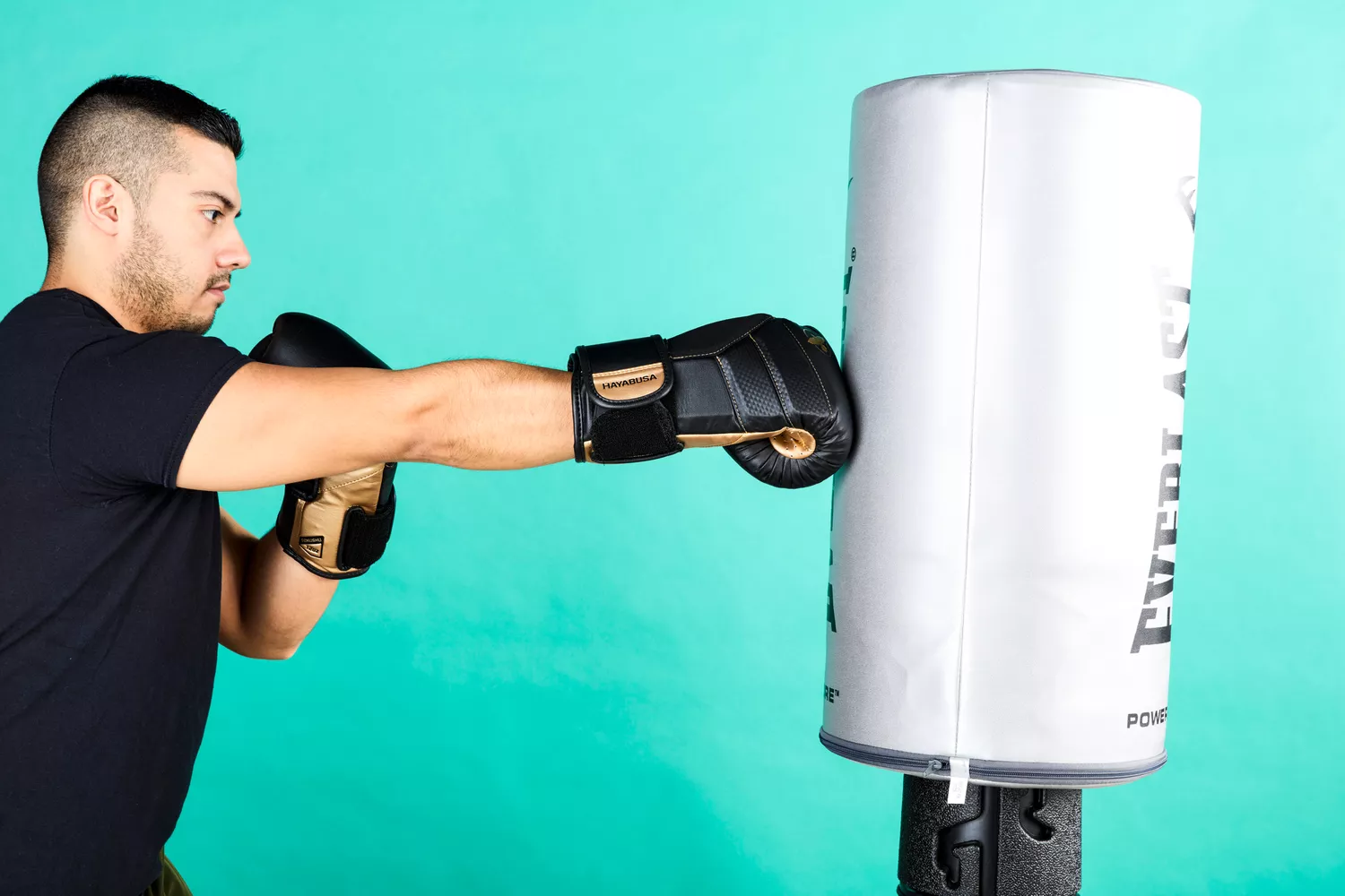 A person hitting a heavy bag while wearing Hayabusa T3 Boxing Gloves