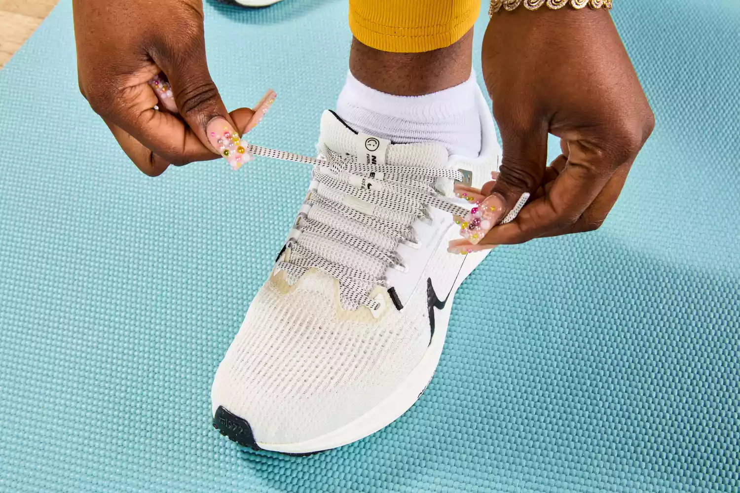 Person tying laces of Nike Women’s Pegasus 40