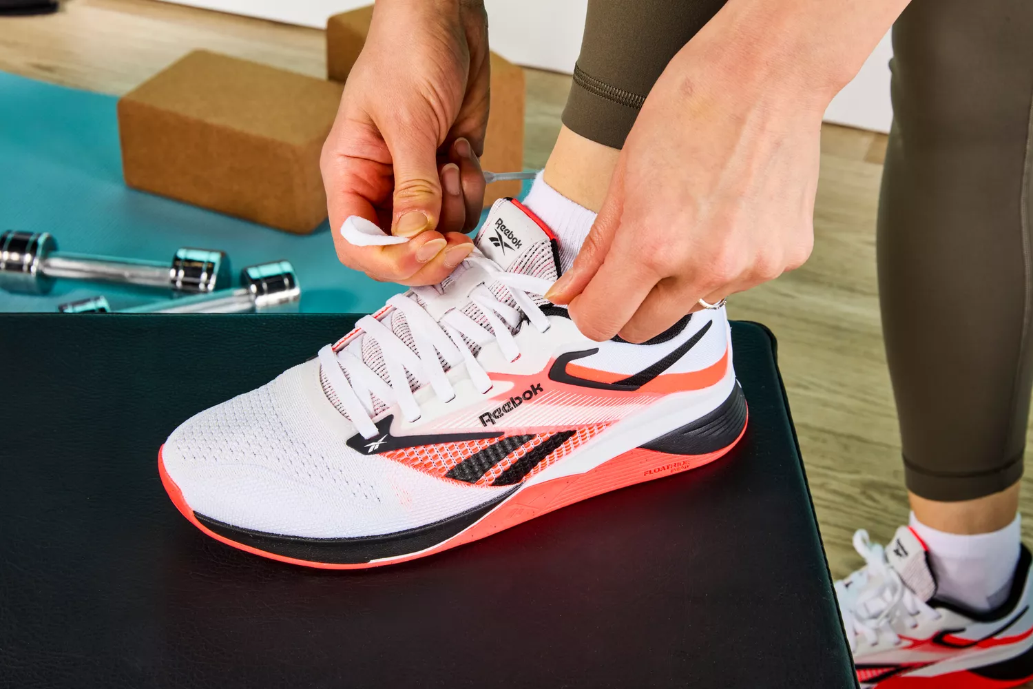 Person tying laces of Reebok Nano X4 Training Shoes