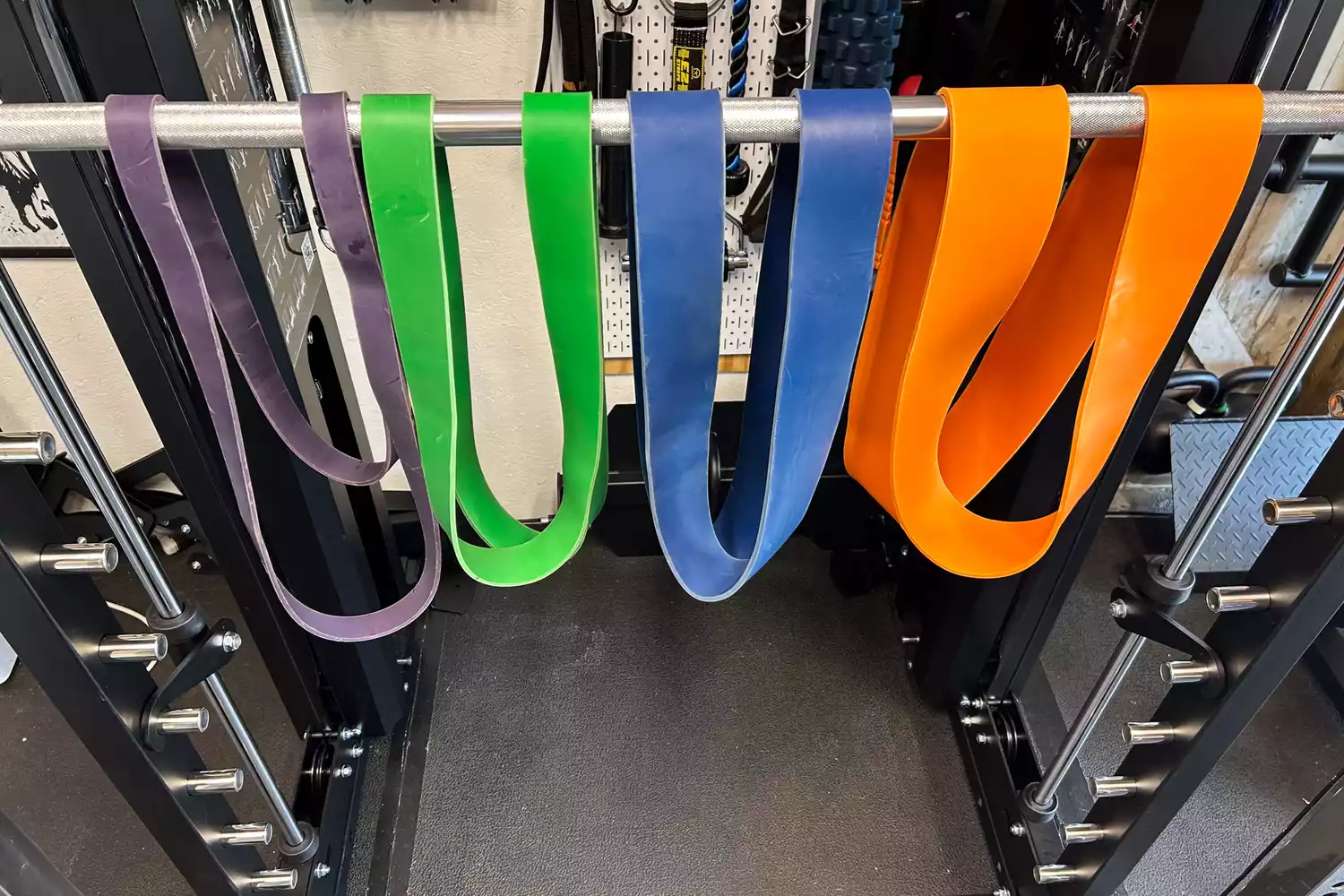 Various Titan Fitness band hanging from a bar
