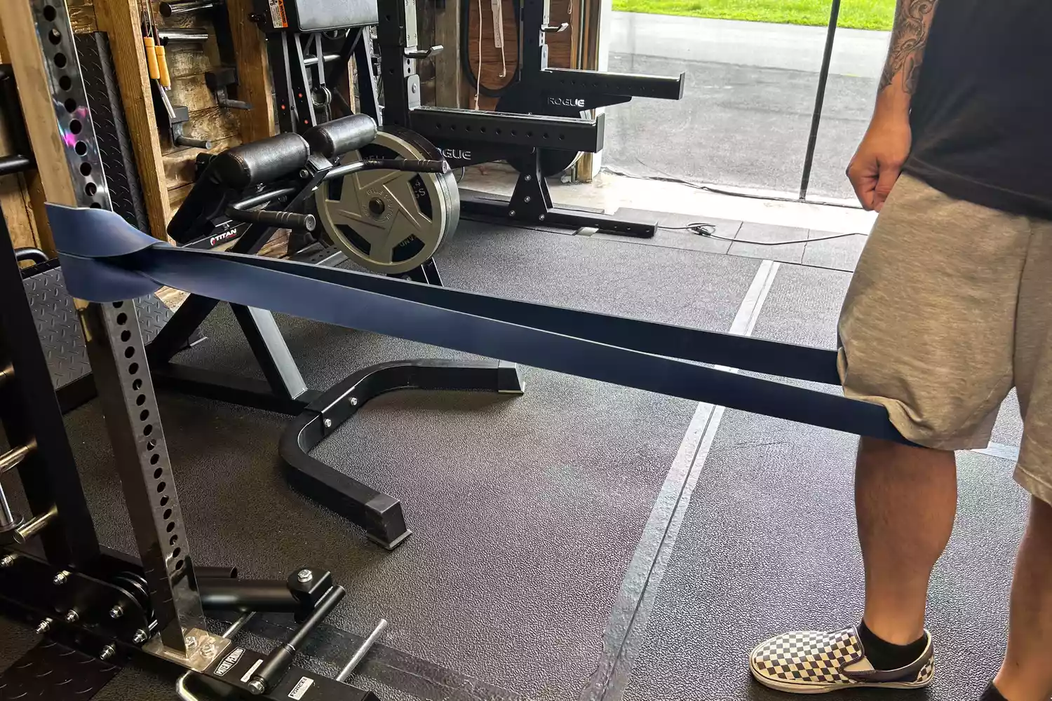 Titan Fitness band looped around a pole and testers leg