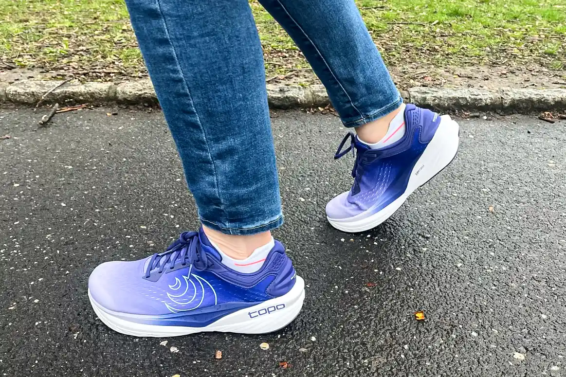 A side view of a person wearing the Topo Athletic Women's Phantom 4 Running Shoes while walking
