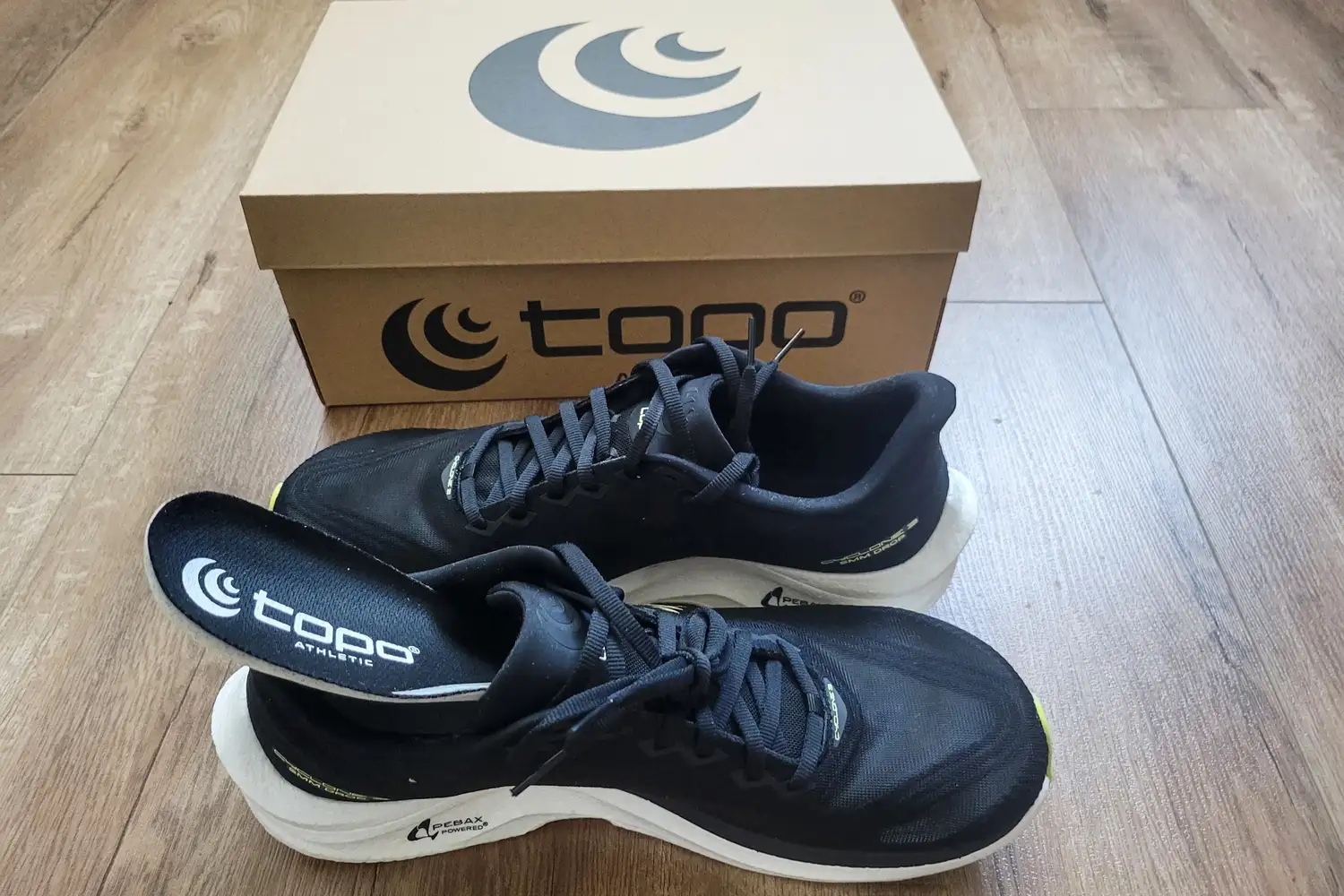 A pair of Topo Athletic Men's Cyclone 3 Road Running Shoes with the insole partially removed