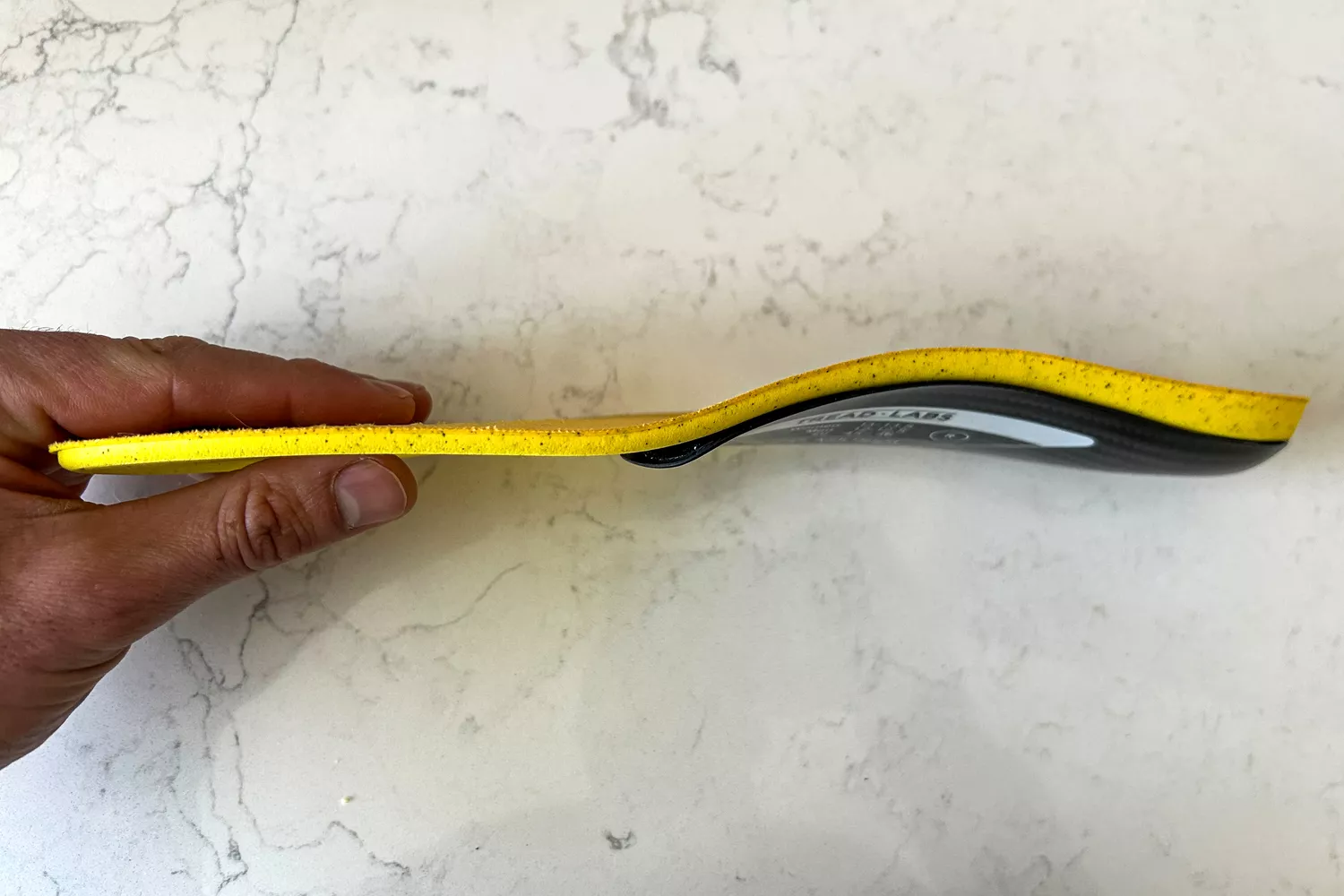A person holds up the Tread Labs Dash Insole