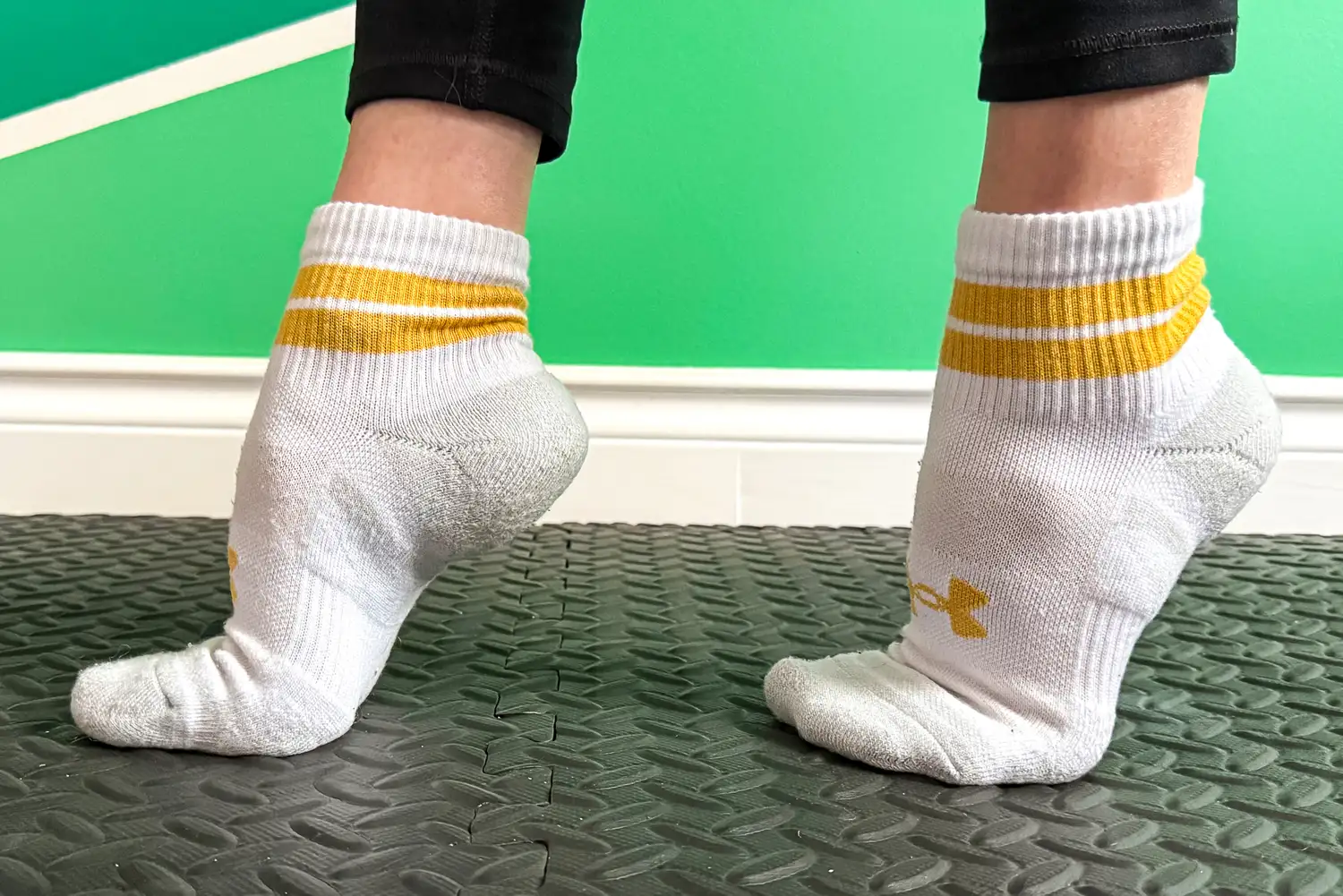 A person wears the Under Armour UA Performance Tech Socks while exercising