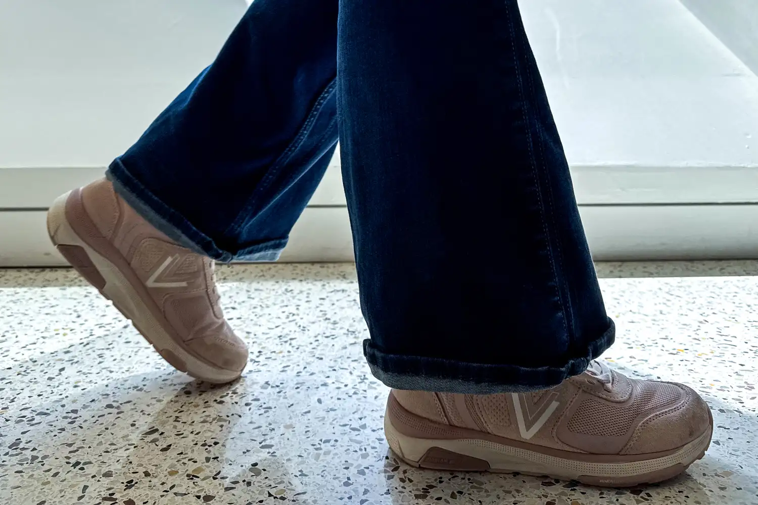A person walking indoors wearing Vionic Women's Walk Strider Sneakers