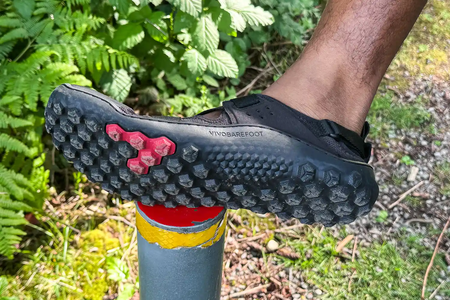 A person wears the Vivobarefoot Men's Tracker Sandal while walking outside