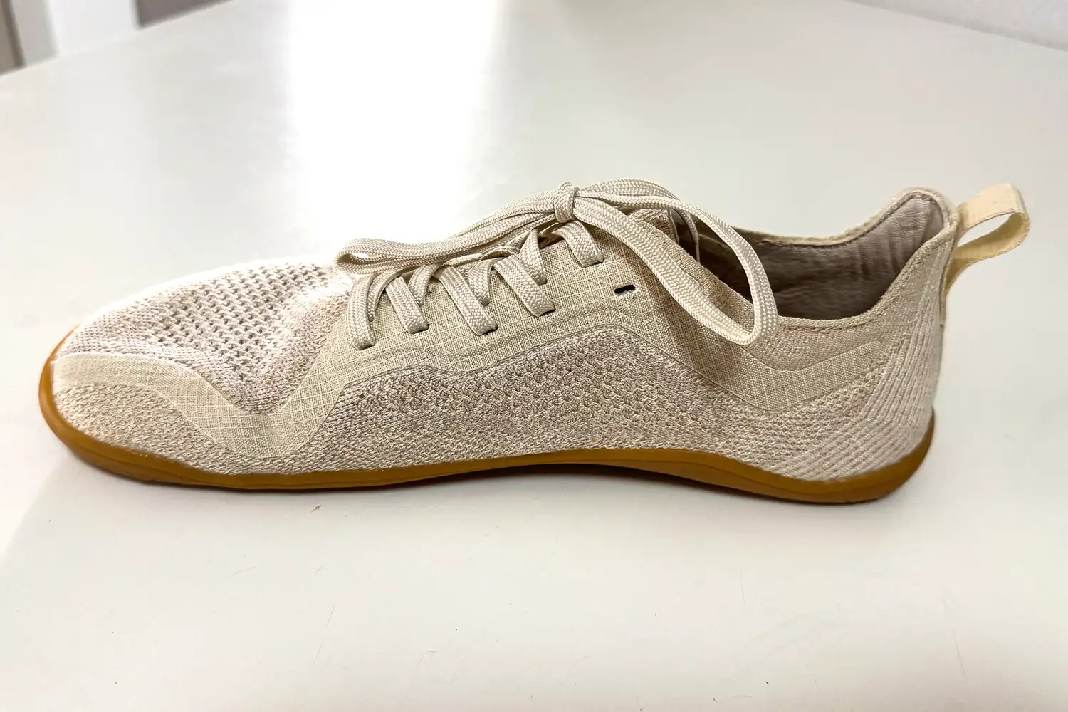 The Vivobarefoot Women's Primus Lite Knit Natural Sneaker on a white table